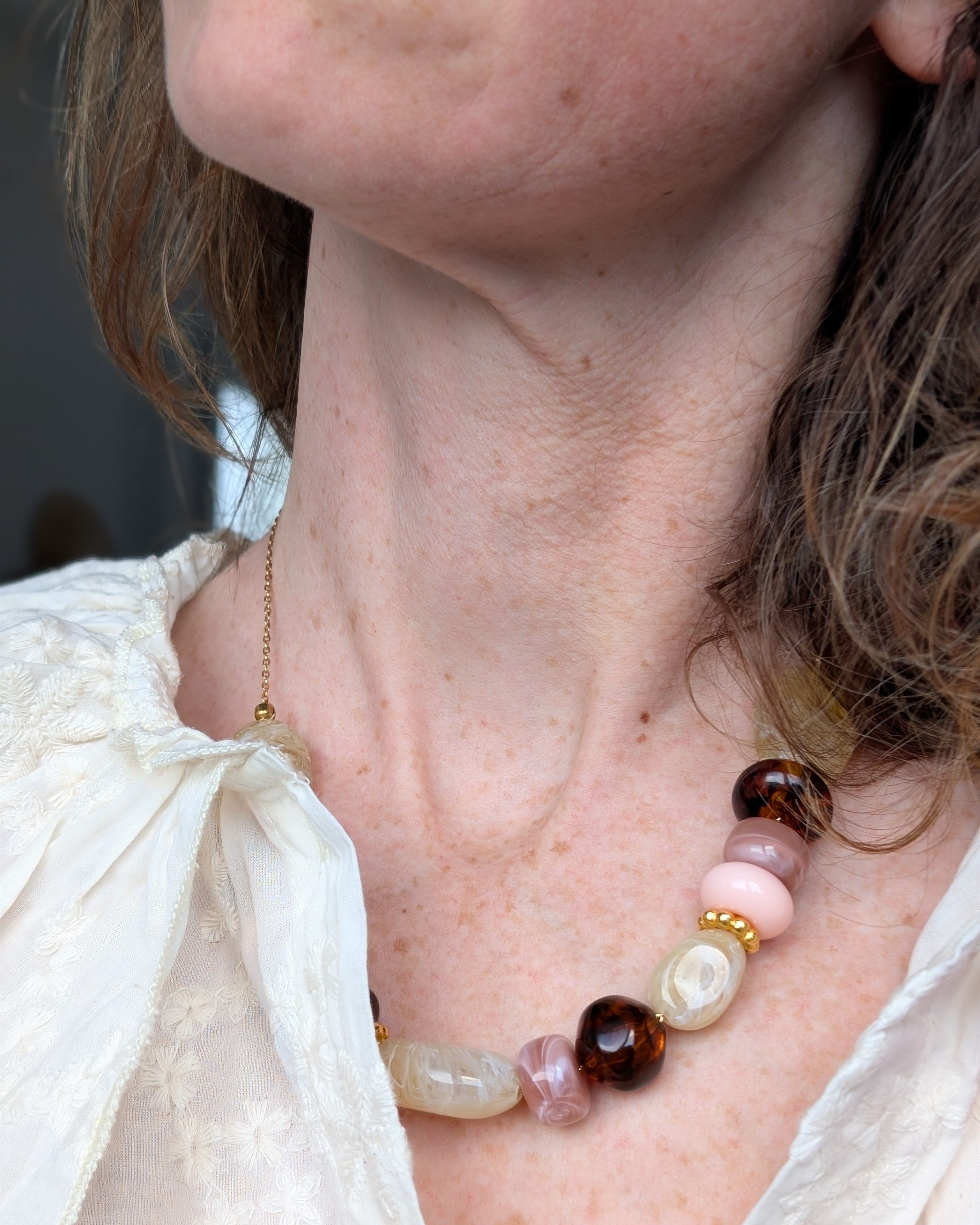 Collier Gabie perle en résine porté par une femme. Créations artisanales La Tête dans les Nétoiles