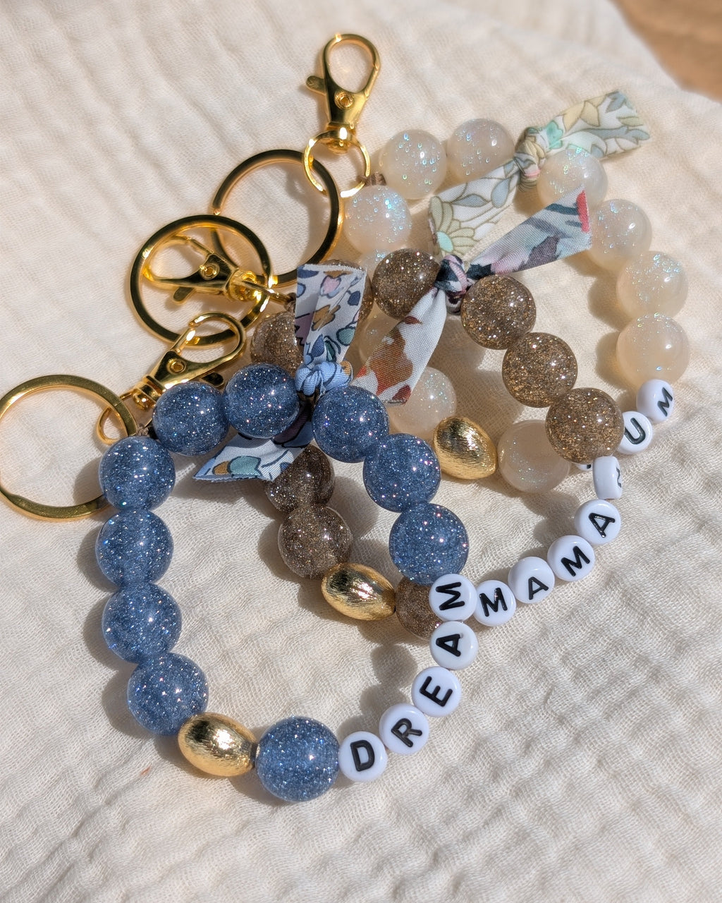 3 bijoux de sac liberty glowy bleu champagne et blanc irisé. Créations artisanales La Tête dans les Nétoiles. 