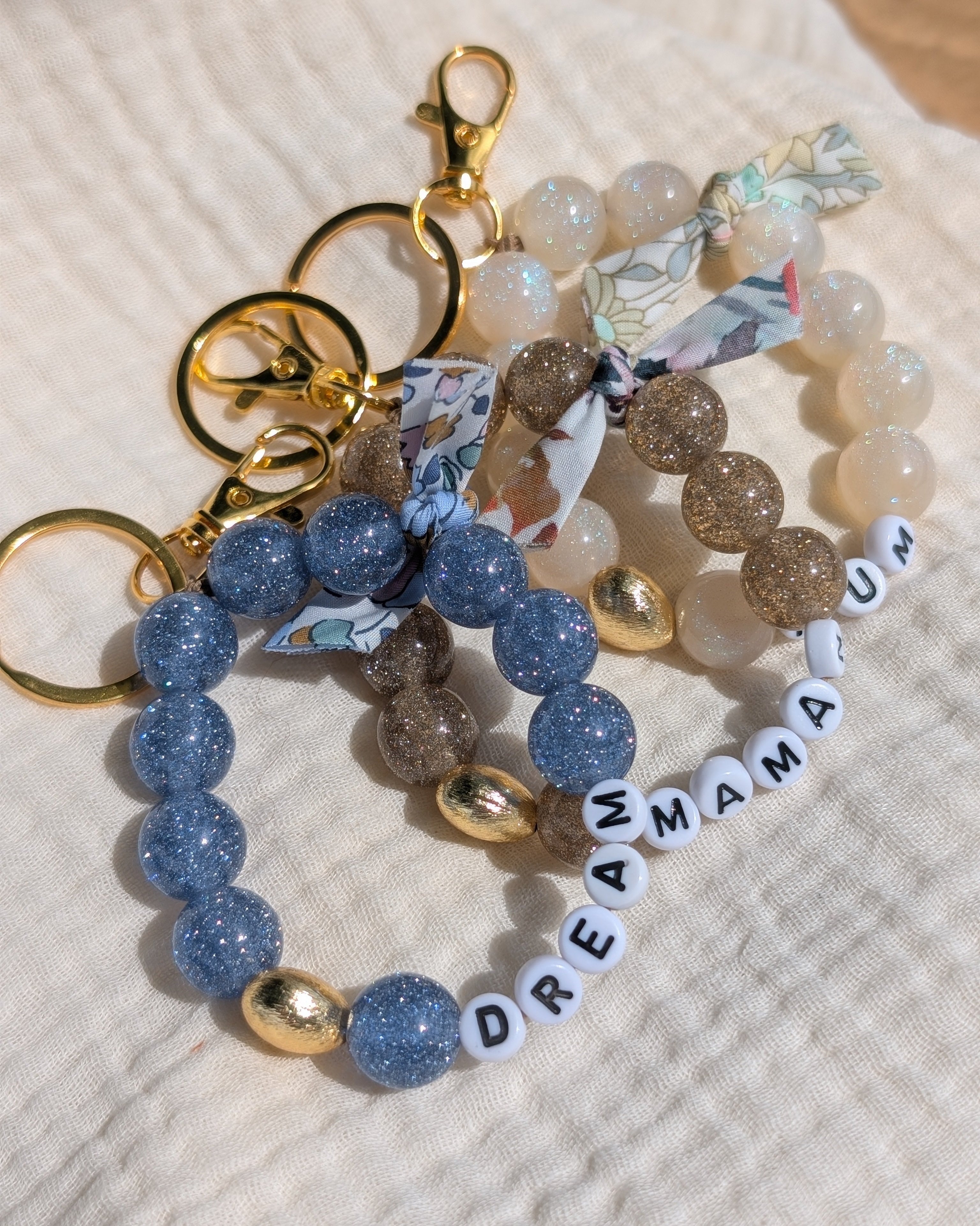 3 bijoux de sac liberty glowy bleu champagne et blanc irisé. Créations artisanales La Tête dans les Nétoiles. 