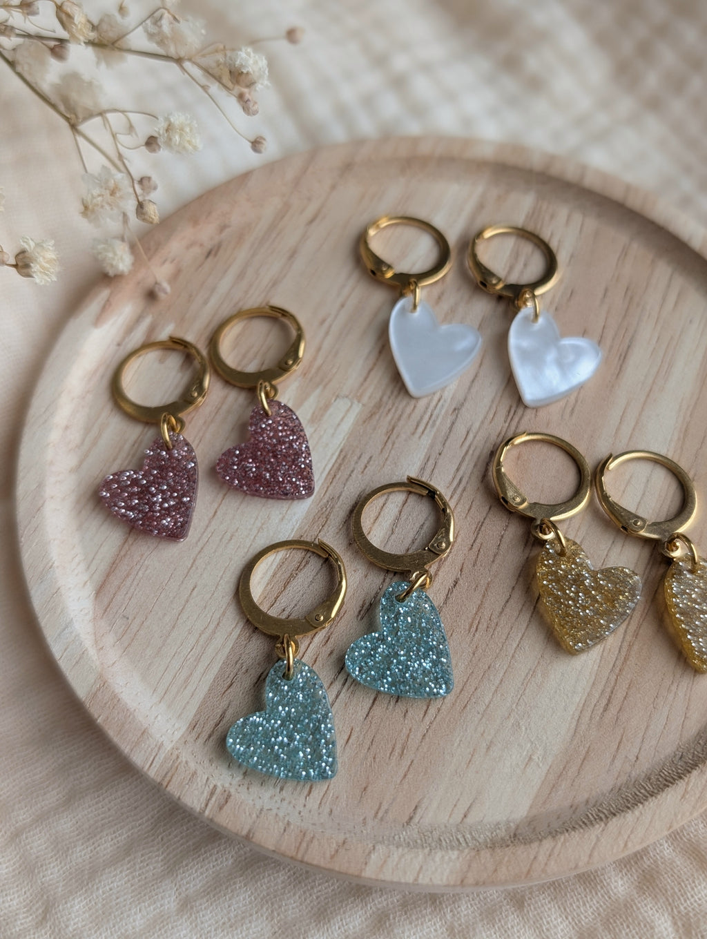 Assortiment de boucles d'oreilles cœurs pour enfant : rose, bleu, blanc nacré et doré pailleté. Créations artisanales pour enfant La Tête dans les Nétoiles.