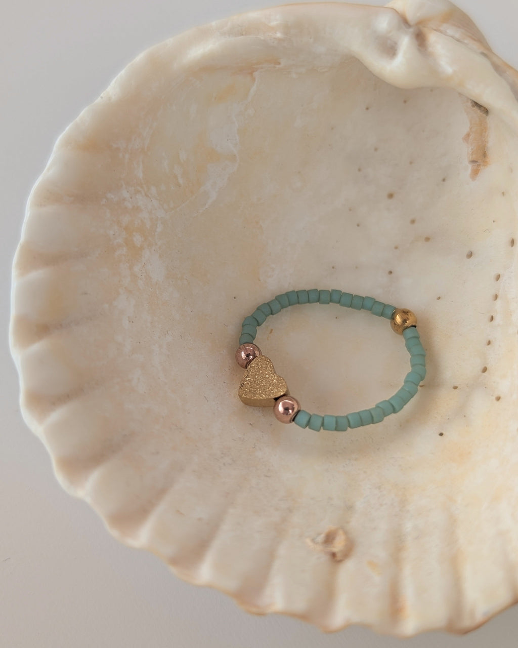 Bague elastique coeur diamanté et perles gold filled. Perles miyuki vert jade posée dans coquillage. Créations artisanales La Tête dans les Nétoiles 