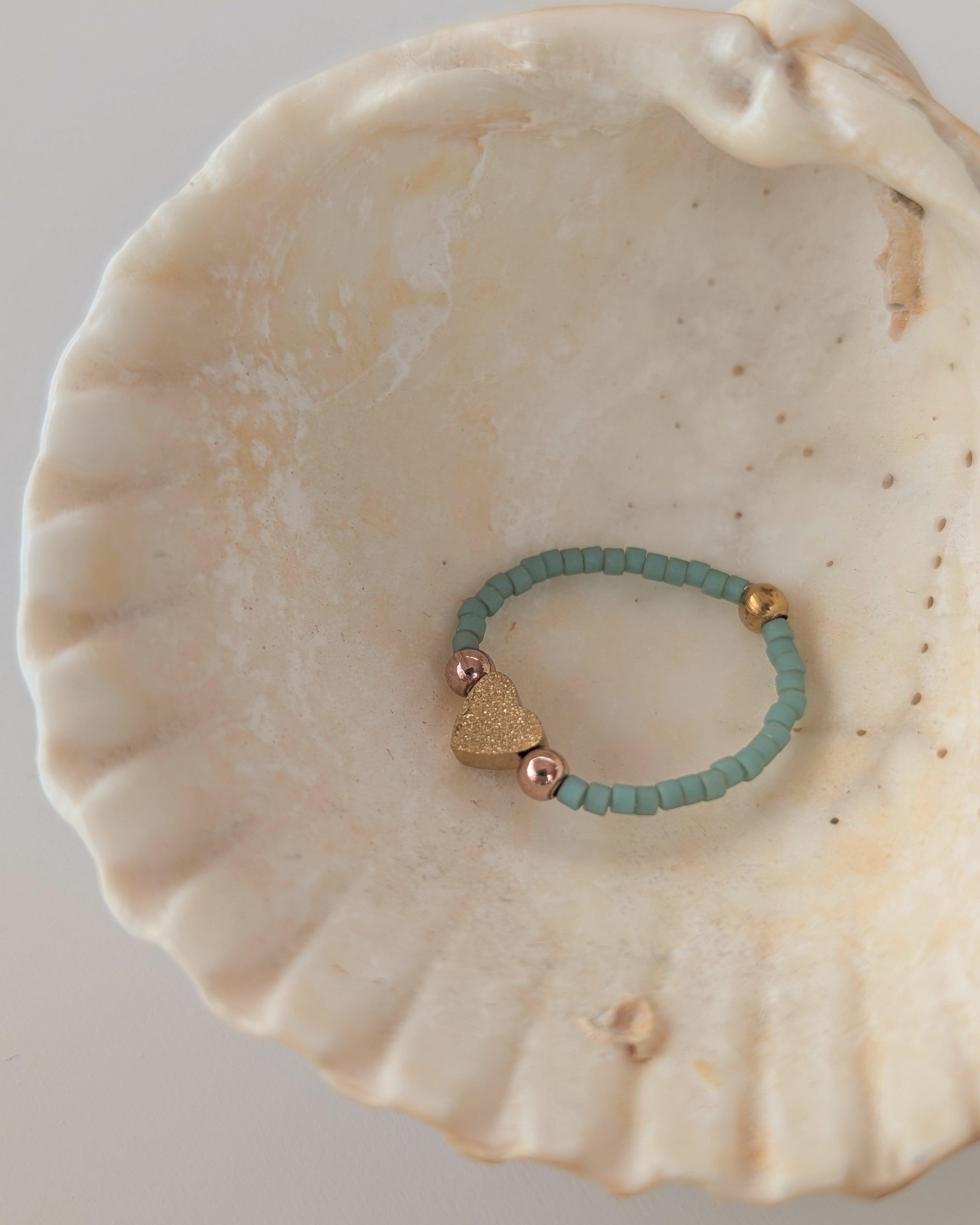 Bague elastique coeur diamanté et perles gold filled. Perles miyuki vert jade posée dans coquillage. Créations artisanales La Tête dans les Nétoiles 
