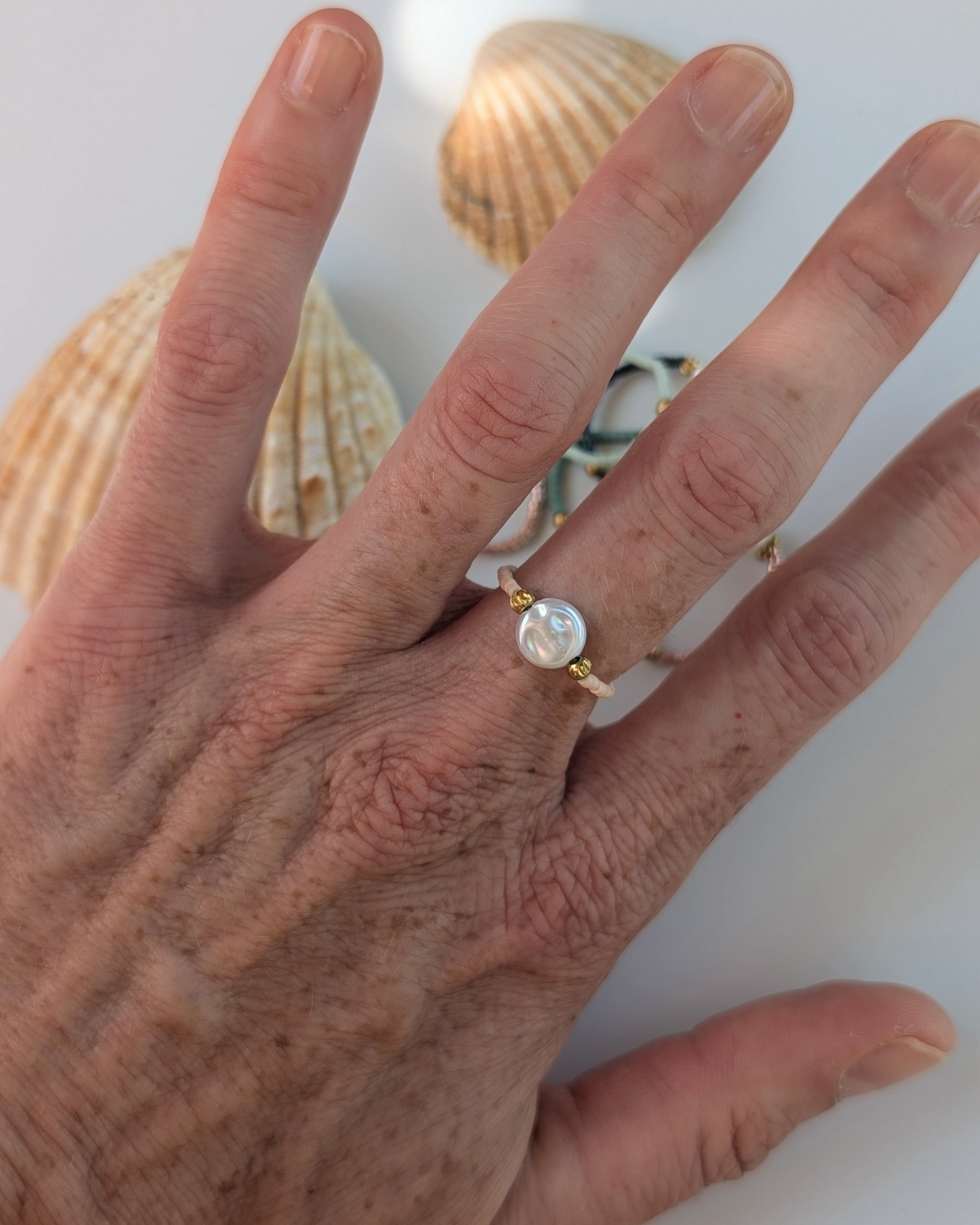 Bague élastique perle d'eau douce irrégulière portée par une femme. Perles miyuki élastique. Créations artisanales La Tête dans les Nétoiles 