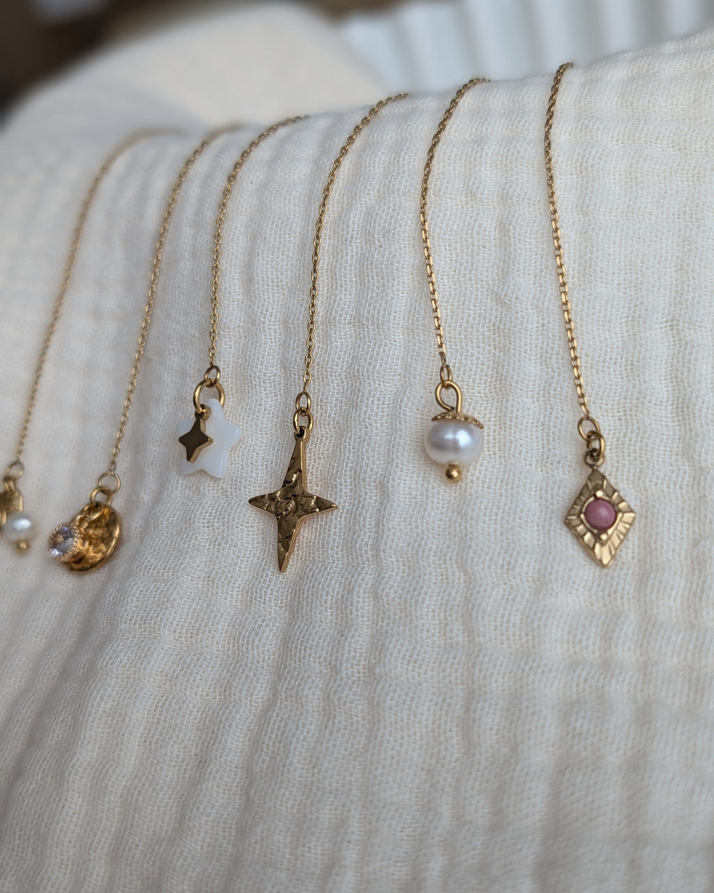 Bar à boucles zoom sur les chainettes d'oreilles et les grigri disponibles photo sur gaze de coton. Créer sa parure. Créations La Tête dans les Nétoiles