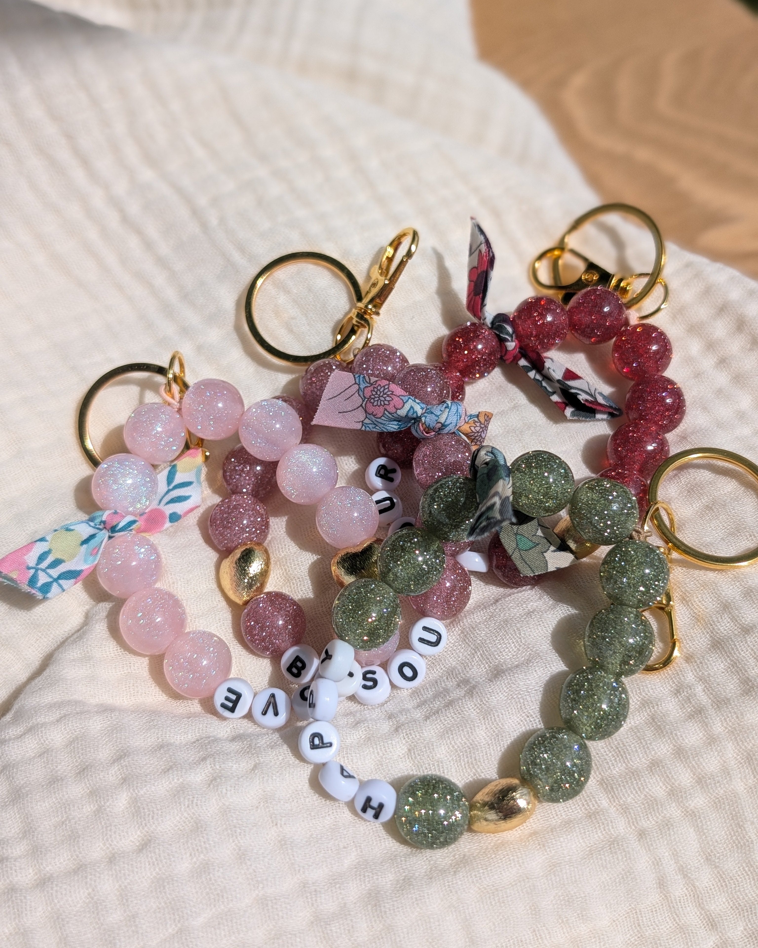 Bijoux de sac personnalisable à message en perles résine paillettes. Créations artisanales La Tête dans les Nétoiles