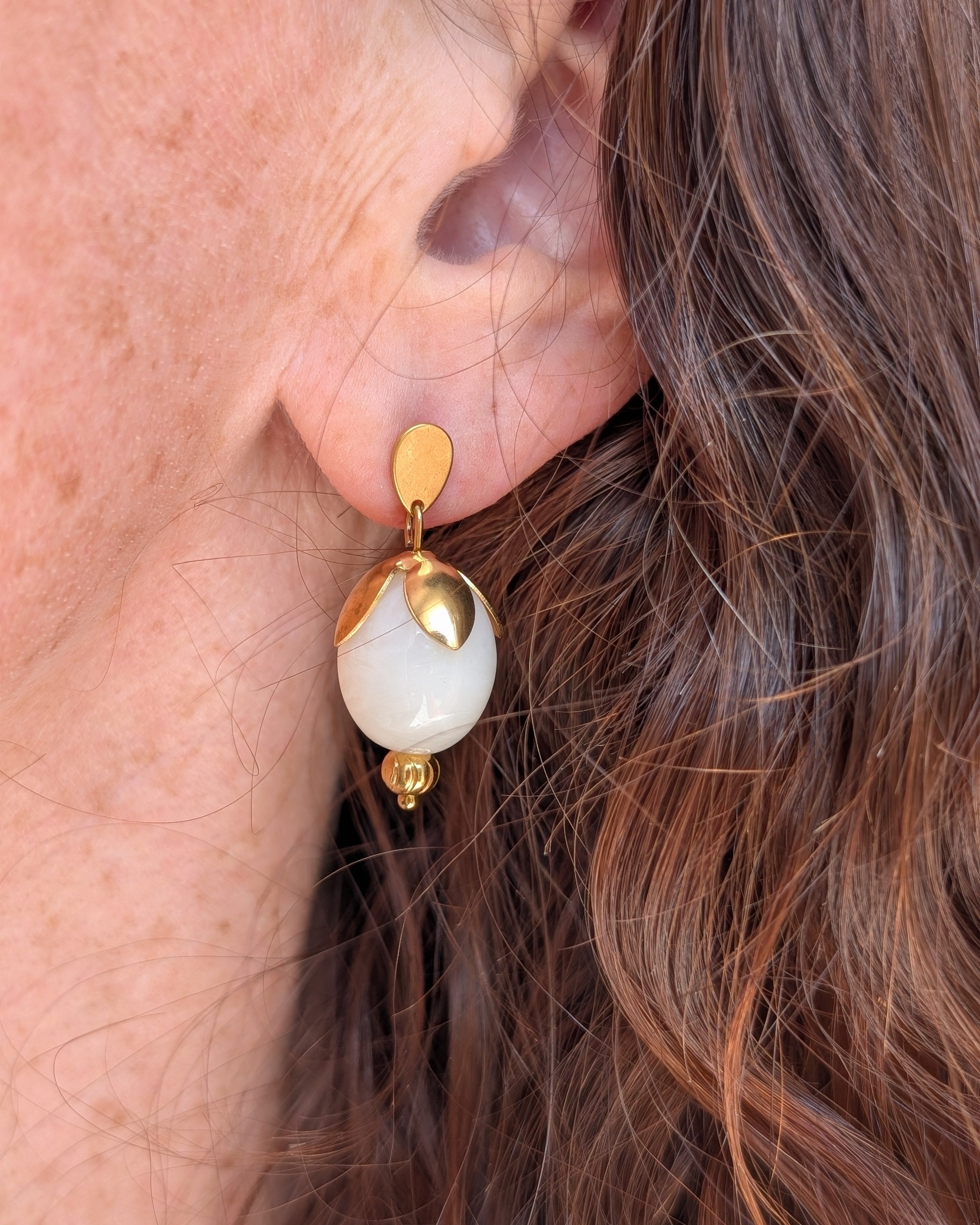 Boucles Olivia perle résine blanc nacré portées par une femme. Créations artisanales La Tête dans les Nétoiles.