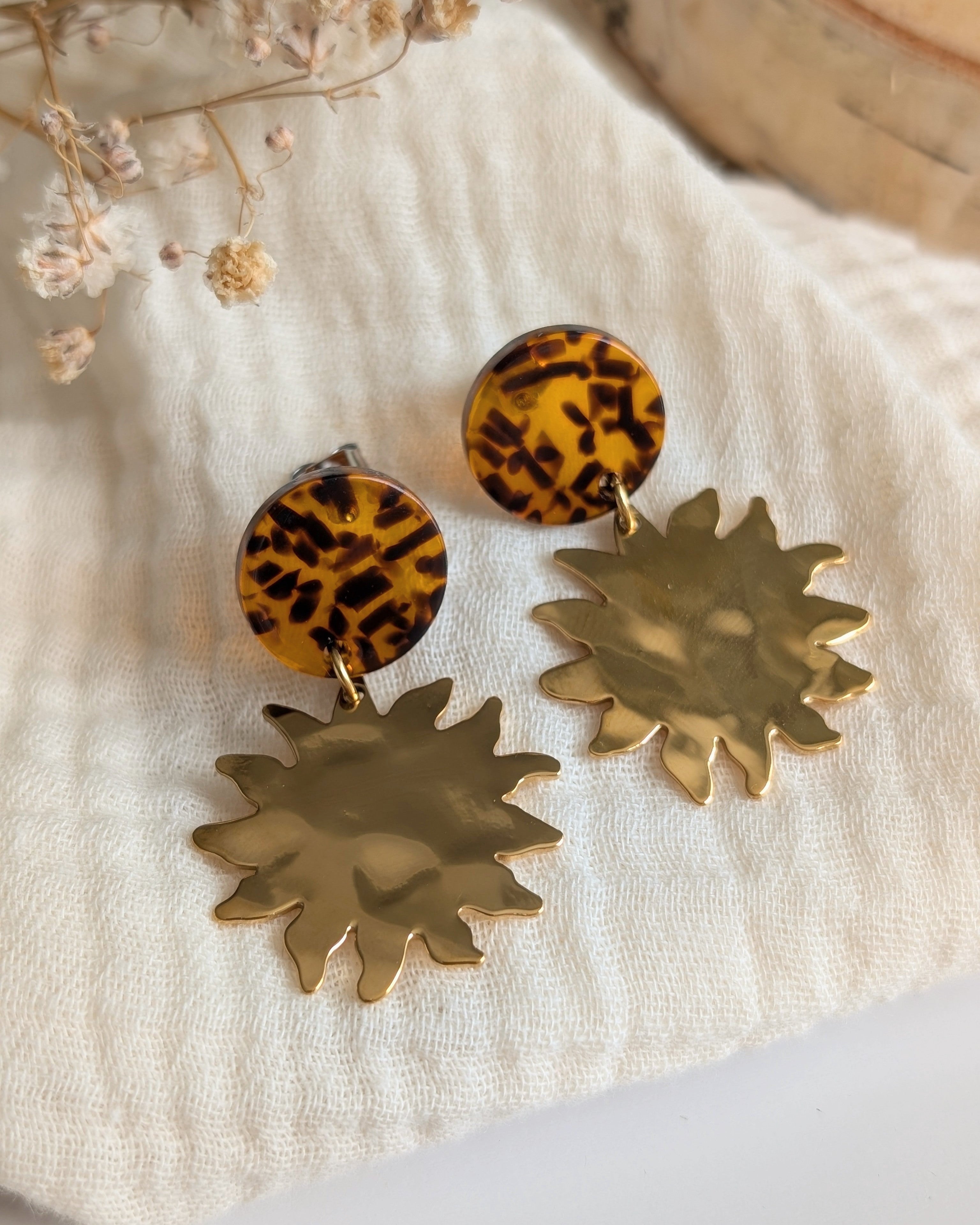 Boucles d'oreilles Soline acétate terrazzo et pendentif soleil acier. Posées sur gaze de coton. Création La Tête dans les Nétoiles