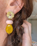 Boucles pendantes Ondine perles résine perle jaune safran et rose lisse. Clous d'oreilles soleil. Portées par une femme. Créations artisanales La Tête dans les Nétoiles