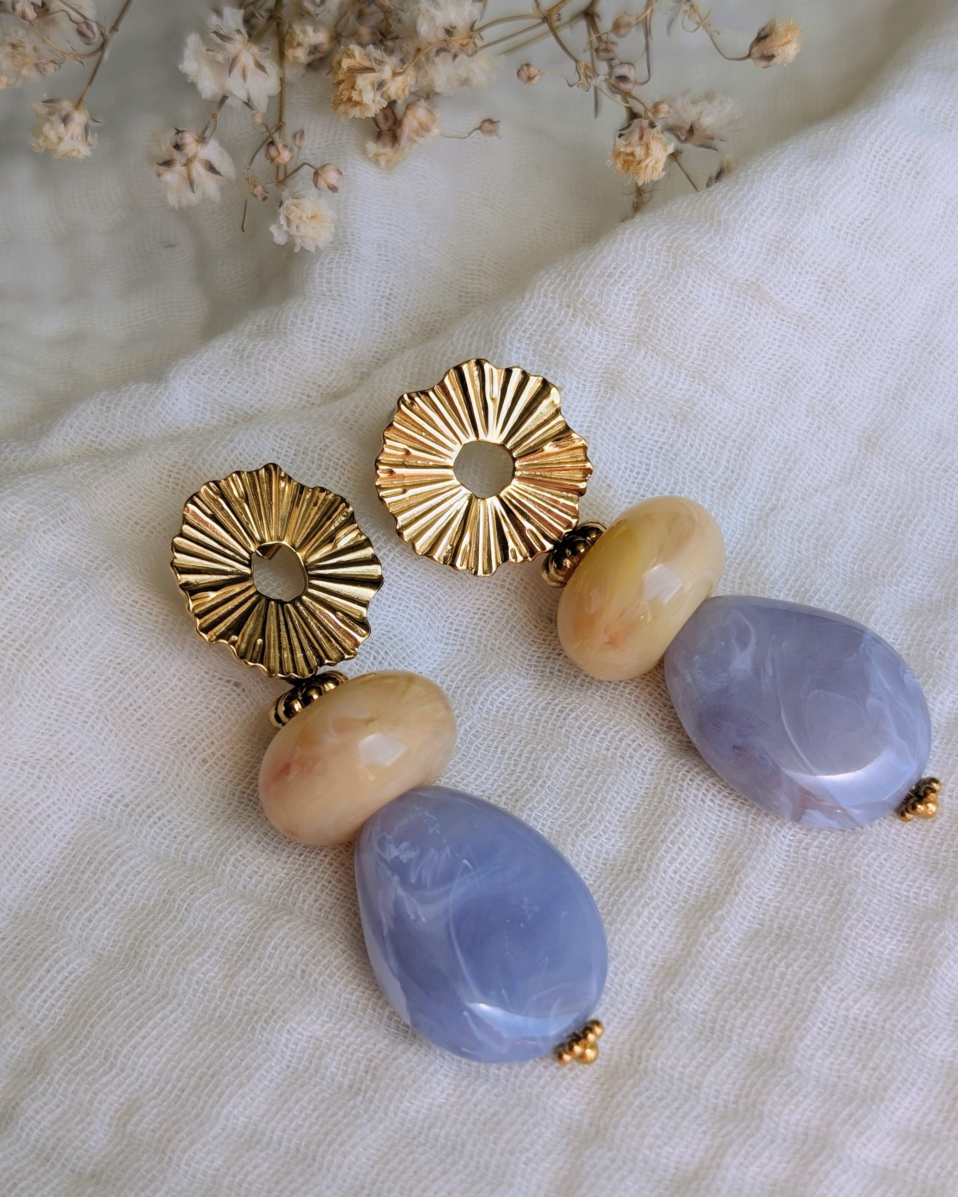 Boucles pendantes Ondine posé sur gaze de coton en version bleu. Soleil et perles en résine. Créations Artisanales la Tête dans les Nétoiles