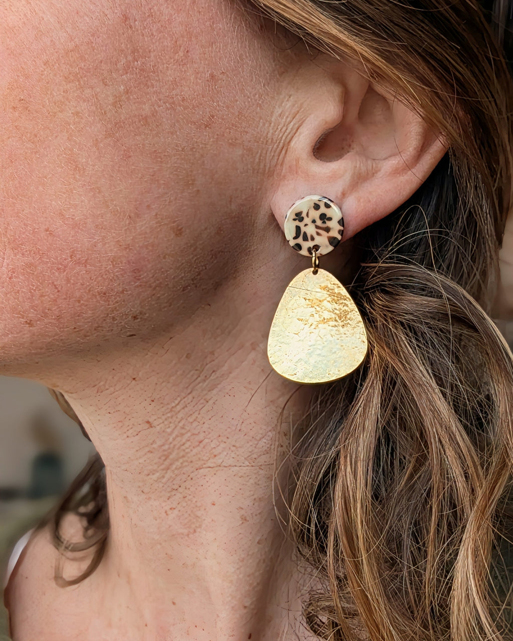 Boucles pendantes Sixtine acétate de celluloseleopard et goutte martelée doré à l'or fin portées par une femme création artisanales La Tête dans les Nétoiles