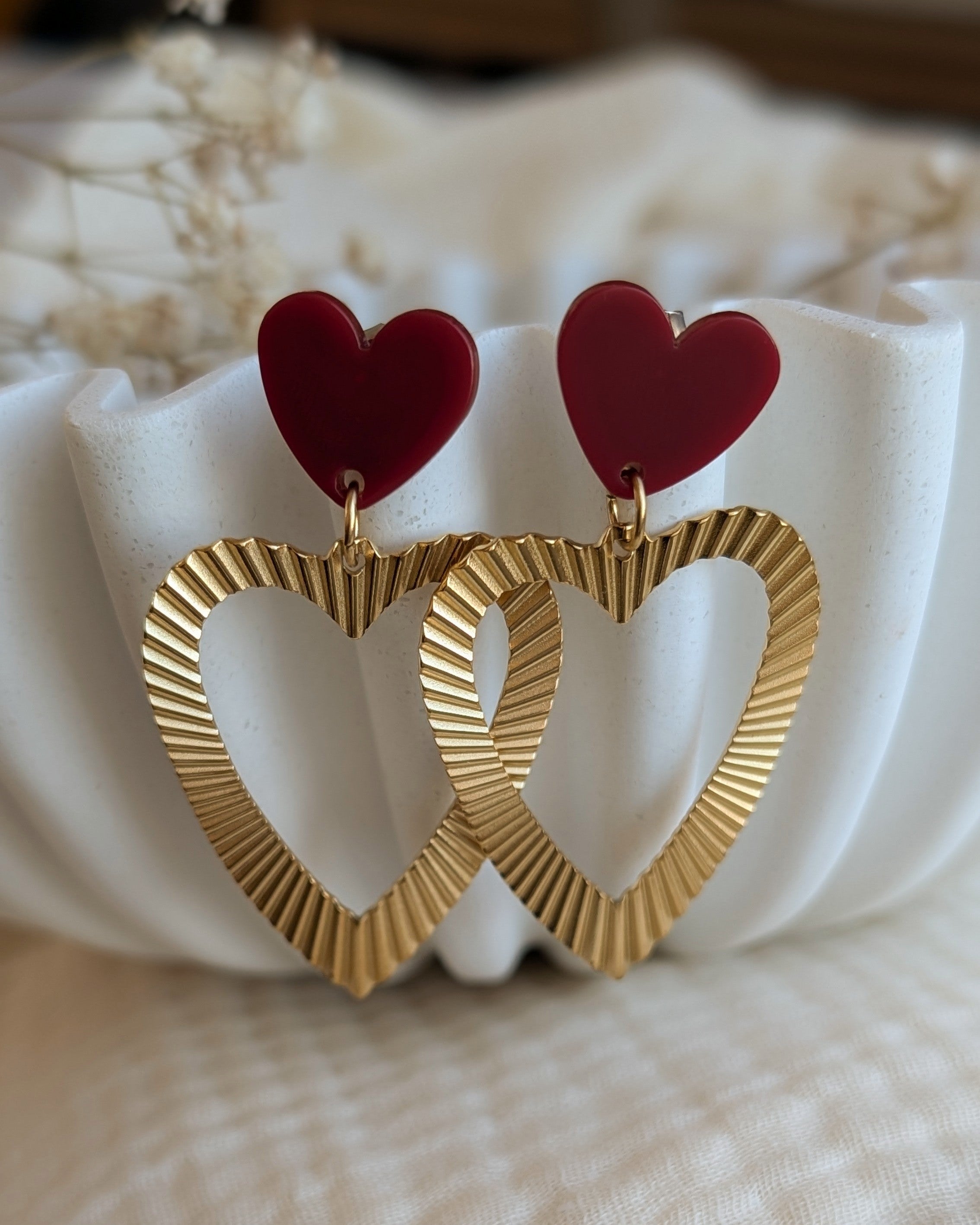Boucles pendantes coeur acier cisele et coeur bordeaux en gros plan creations artisanales La Tete dans les Netoiles