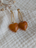 Boucles pendantes Aélia coeur résine abricot posées sur gaze de coton. Création La Tête dans les nétoiles