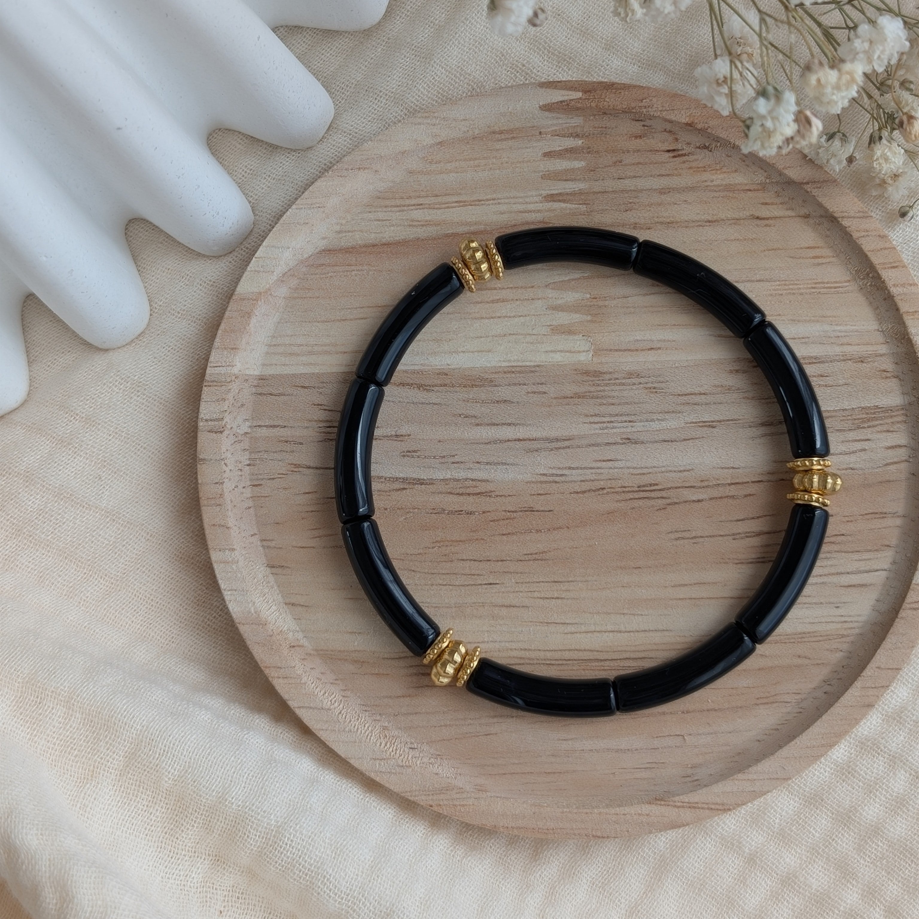 Bracelet JUNE noir sur support en bois. Création La Tête dans les Nétoiles