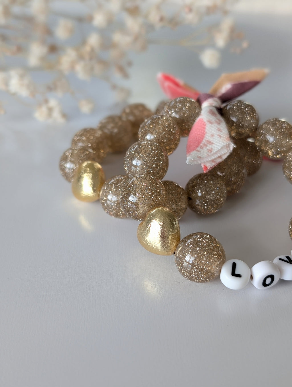 Bracelet LIBERTY GLOWY perle champagne doré photo en gros plan. Bracelet à message duo mère fille. Créations La Tête dans les Nétoiles