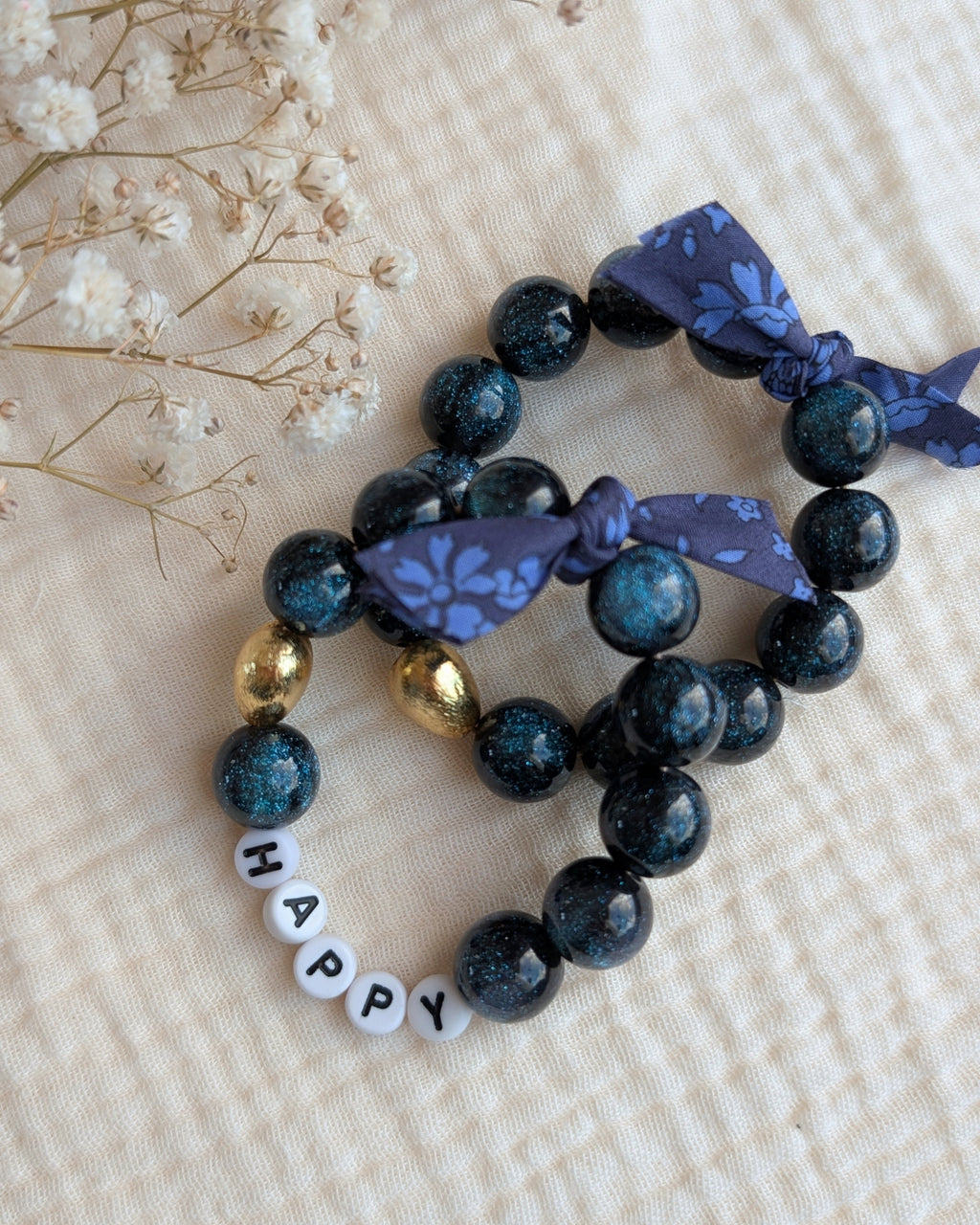 Bracelet LIBERTY GLOWY perles bleu nuit à paillettes avec mots doux duo mère fille. Perle en résine coeur en plaqué or. bijoux personnallisés. Créations artisanales La Tête dans les Nétoiles