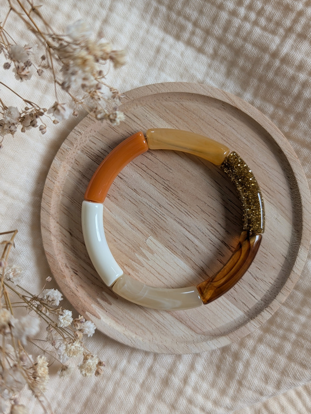 Bracelet LISA ambre orange perle tube sur support en bois. Création La Tête dans les Nétoiles