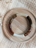 Bracelet LISA perle tube marron leopard sur support en bois.