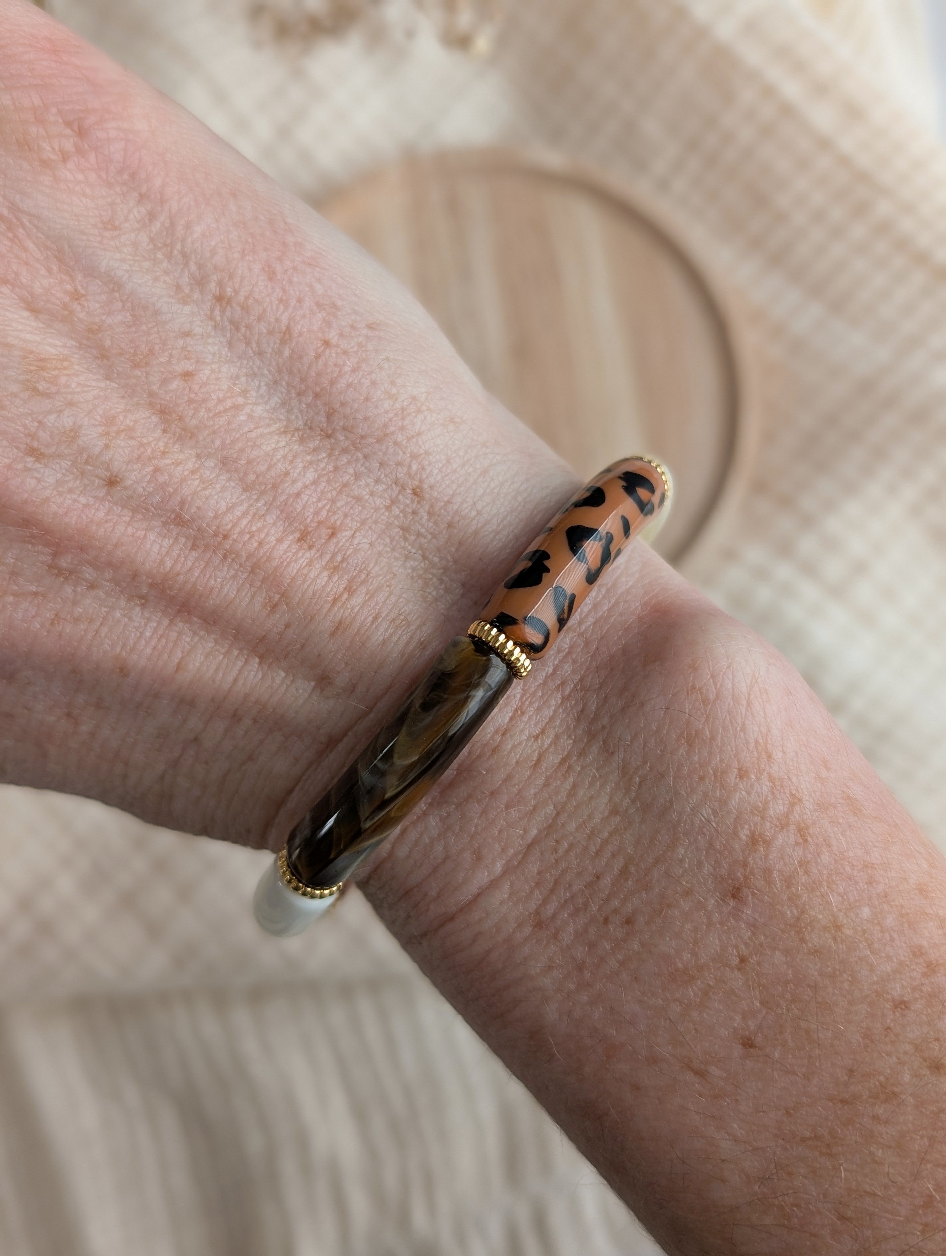 Bracelet Lison porté au poignet. Perles tube et perles intercalaires dorées métal DQ. Créations La Tête dans les Nétoiles