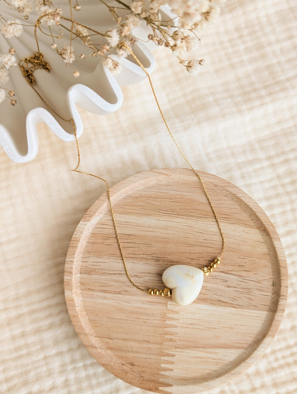 Collier MARCELLE coeur en résine crème marbré sur chaîne maille en serpentine en acier inoxydable doré. Créations artisanales La Tête dans les Nétoiles