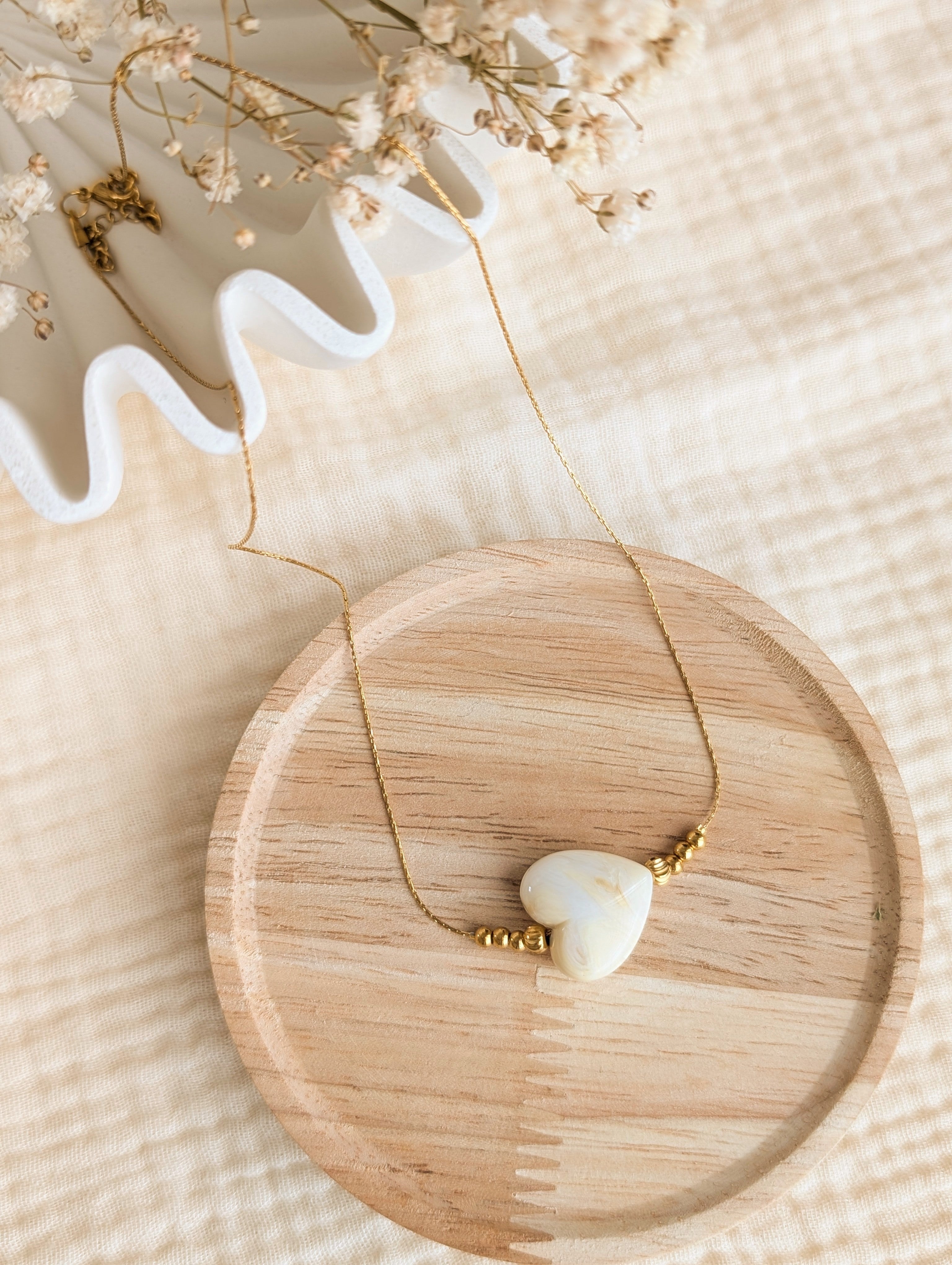 Collier MARCELLE coeur en résine crème marbré sur chaîne maille en serpentine en acier inoxydable doré. Créations artisanales La Tête dans les Nétoiles
