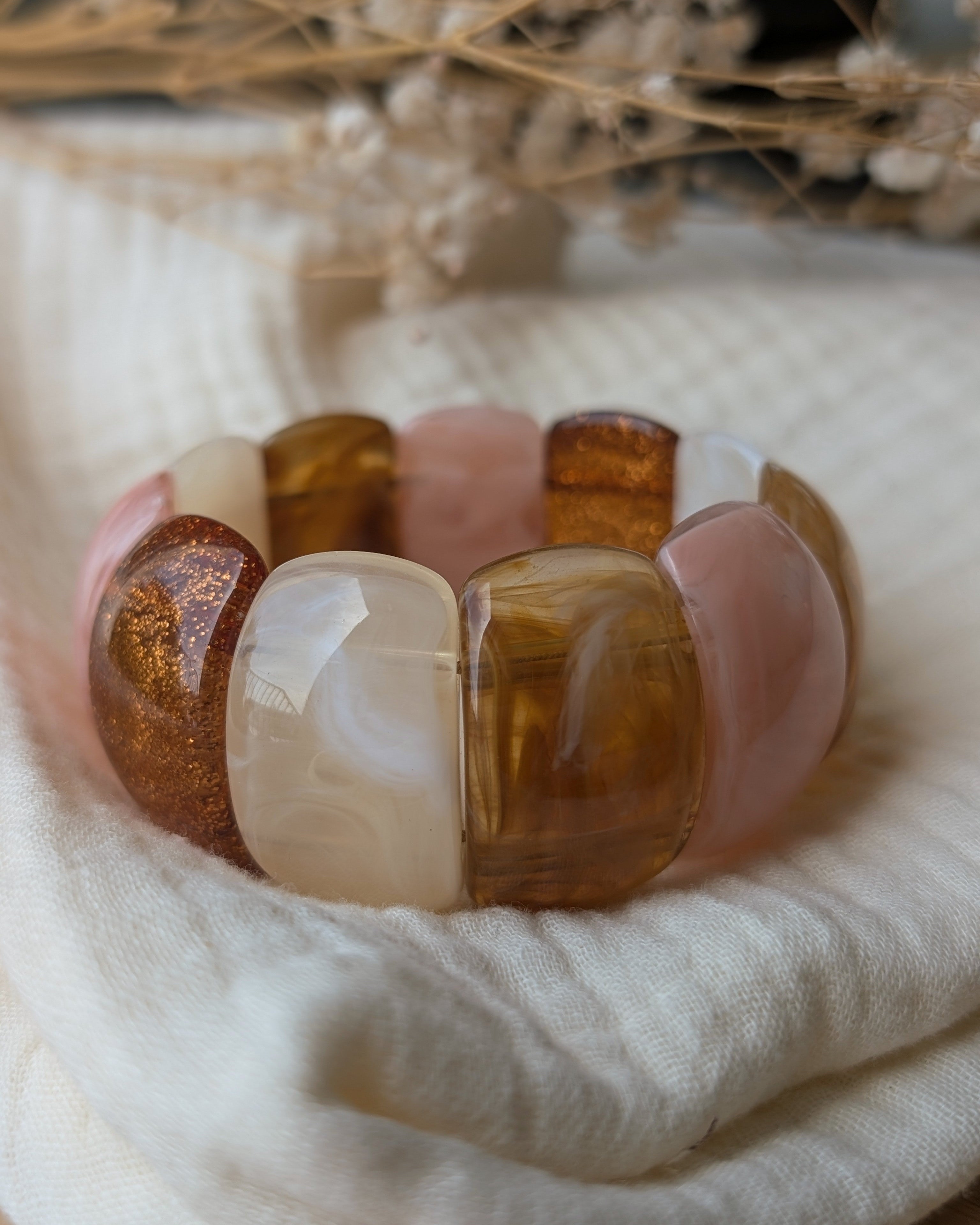Bracelet Ysée miel rose écru posé sur gaze de coton. Création artistique La Tête dans les Nétoiles 