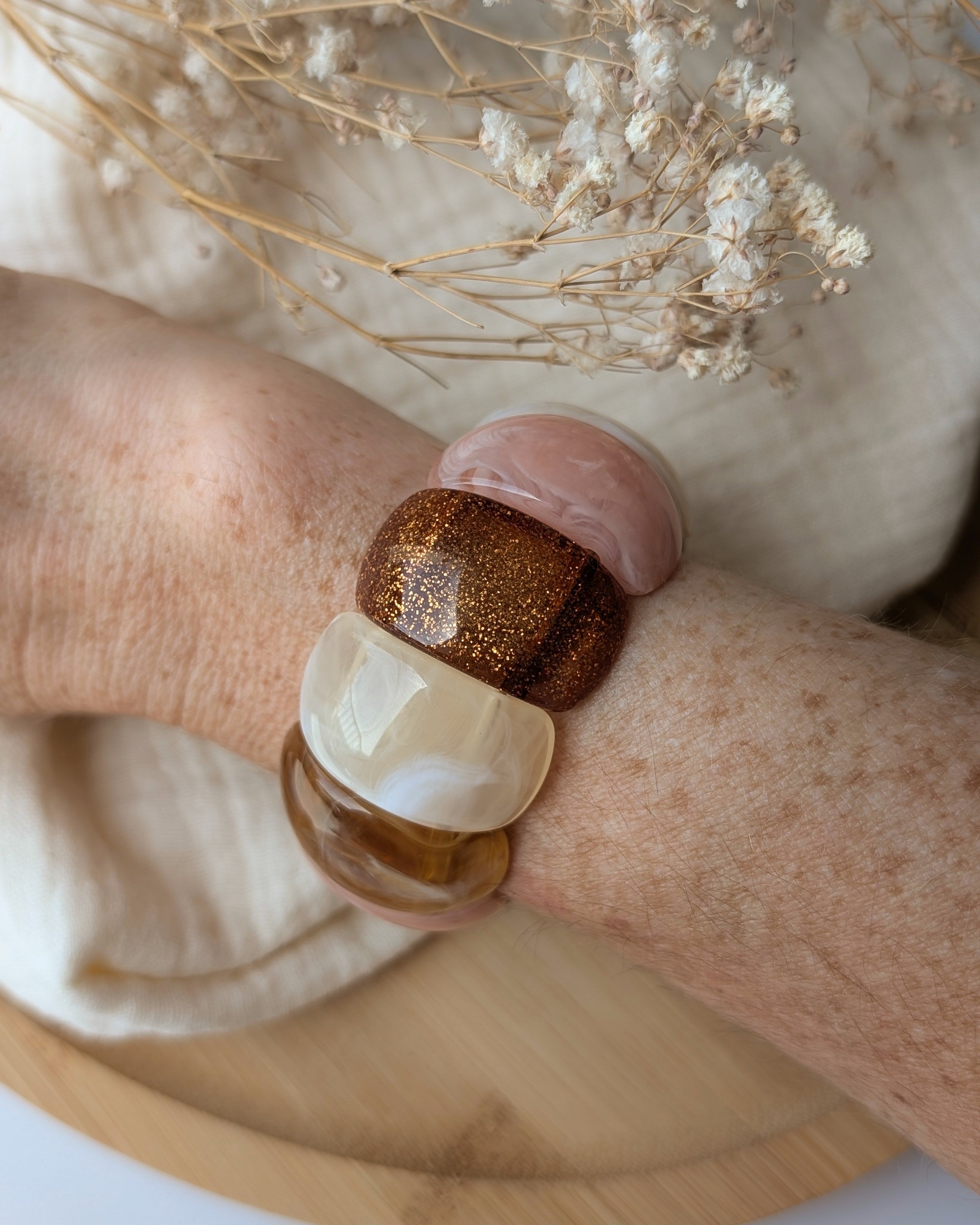 Bracelet Ysée miel rose écru porté au poignet. Création artisanale La Tête dans les Nétoiles 