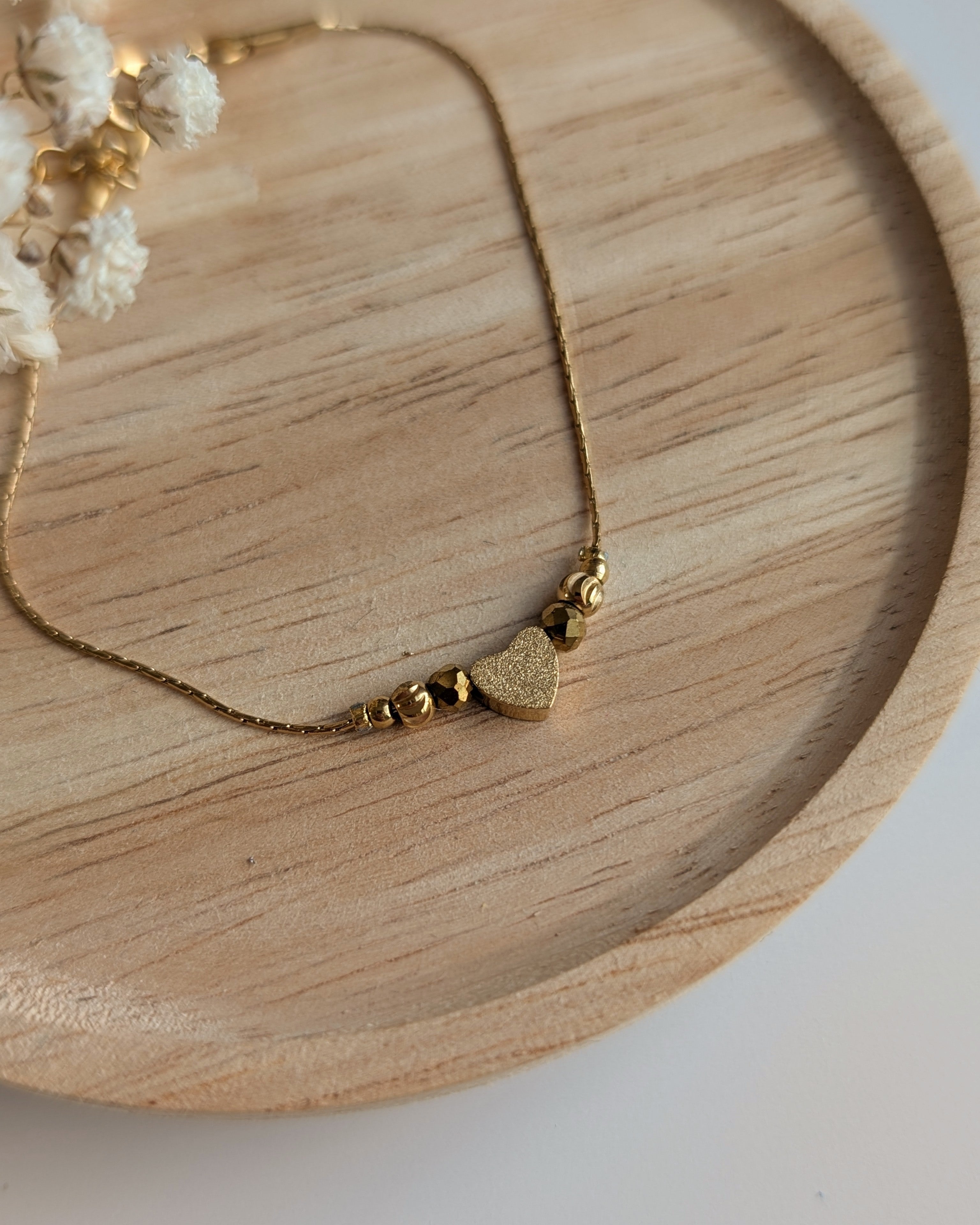 Bracelet fin chaine maille serpentine en acier inoxydable doré et perle coeur diamanté et  en verre doré. Créations la Tête dans les Nétoiles