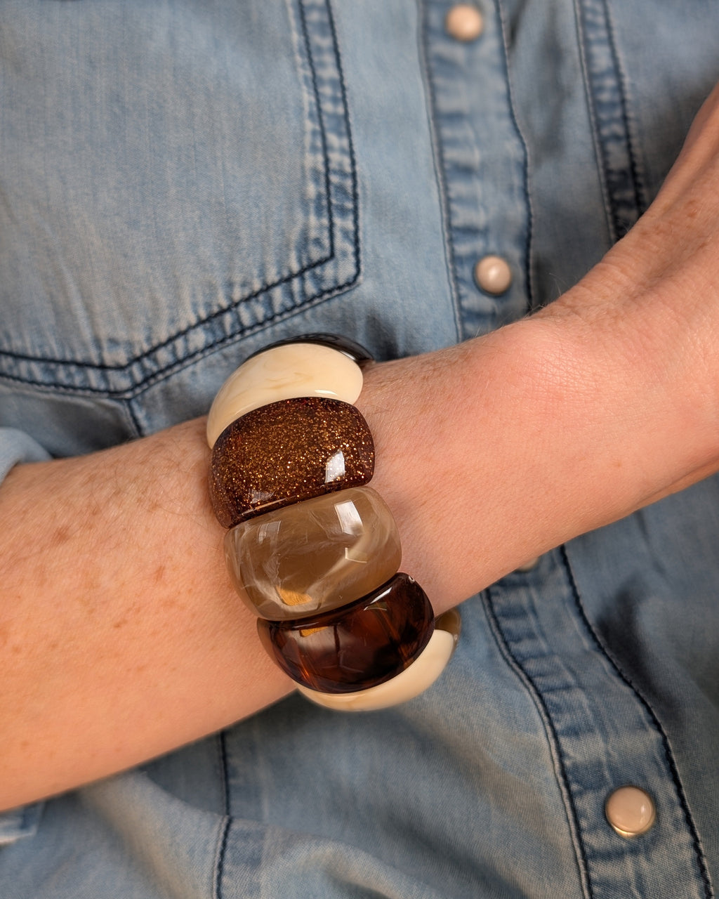 Bracelet manchette Ysée nuance de marron glitter porété par une femme. Création La Tête dans les Nétoiles