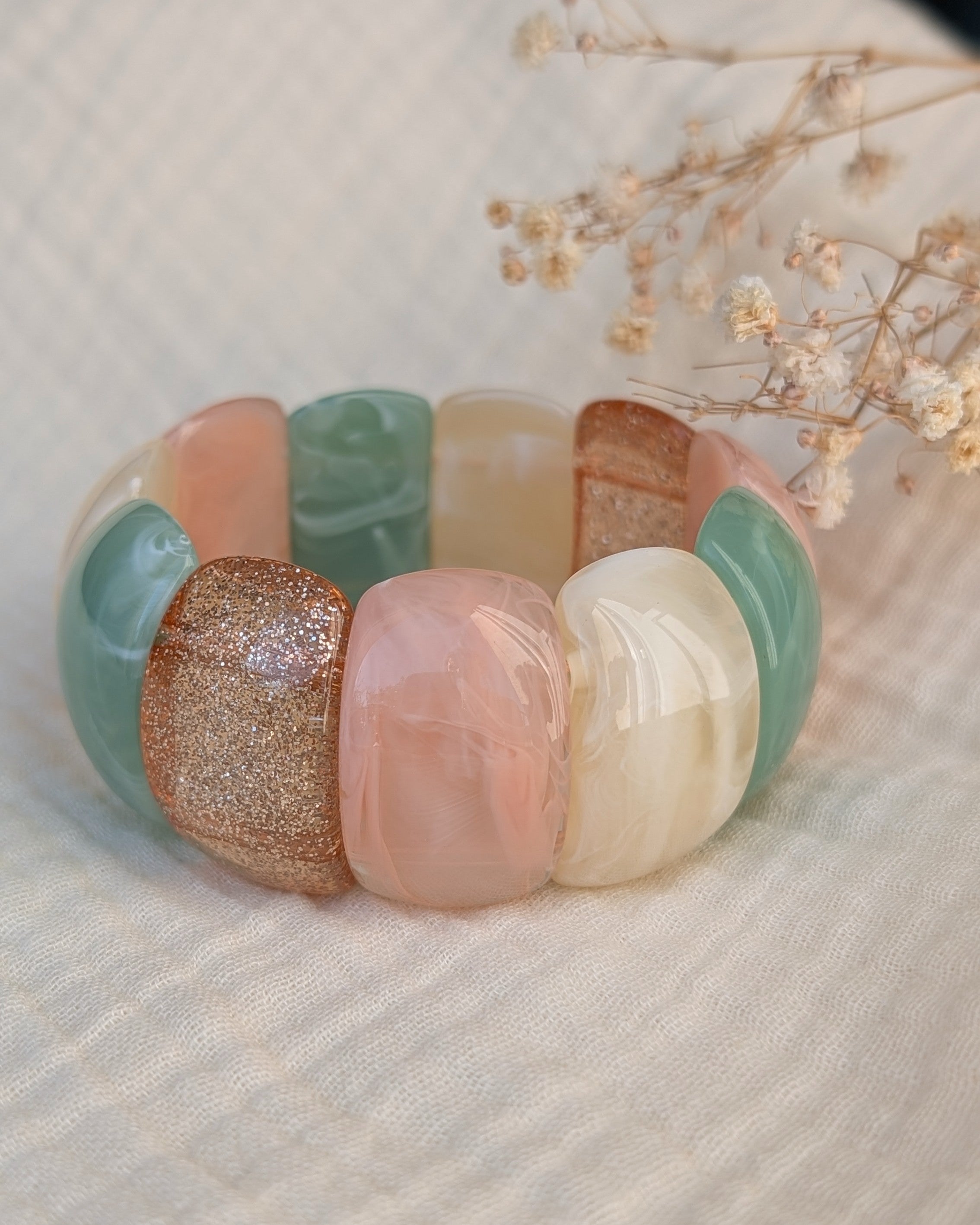Bracelet manchette Ysée Rose vert écru champagne doré paillettes. Posé sur gaze de coton. Créations artisanales La Tête dans les Nétoiles.