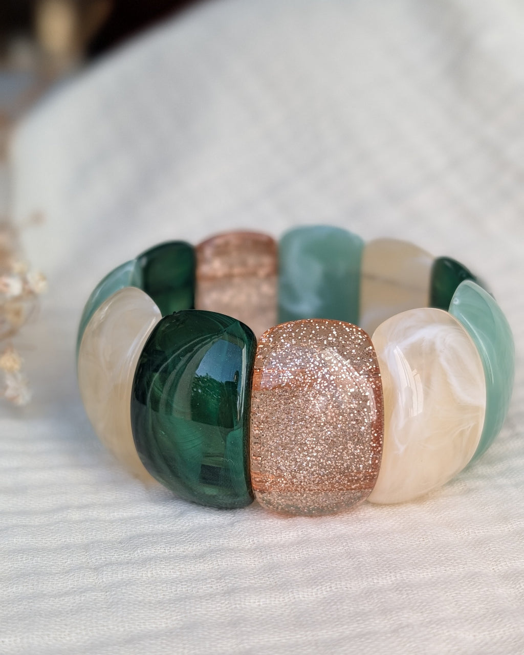 Bracelet manchette élastique Ysée vert 
Bracelet manchette Ysée perles sauge et vert marbré posé sur gaze de coton. Création artisanale la Tête dans les Nétoiles 