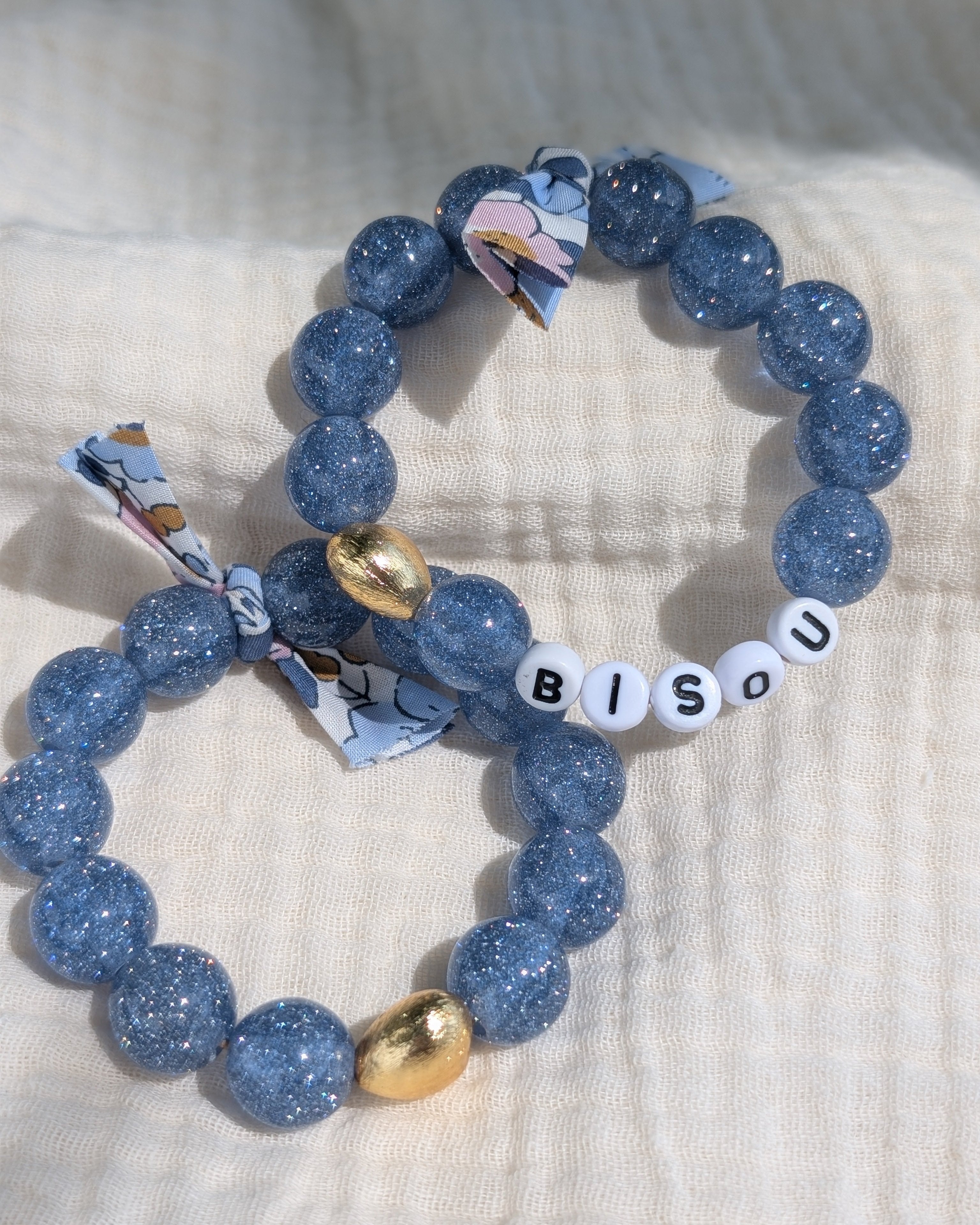 2 Bracelets perle coeur paillettes à message et ruban liberty. Colori bleu clair. un avec  le mot bisou et un sans mot. Personnalisable. Créations La Tête dans les Nétoiles