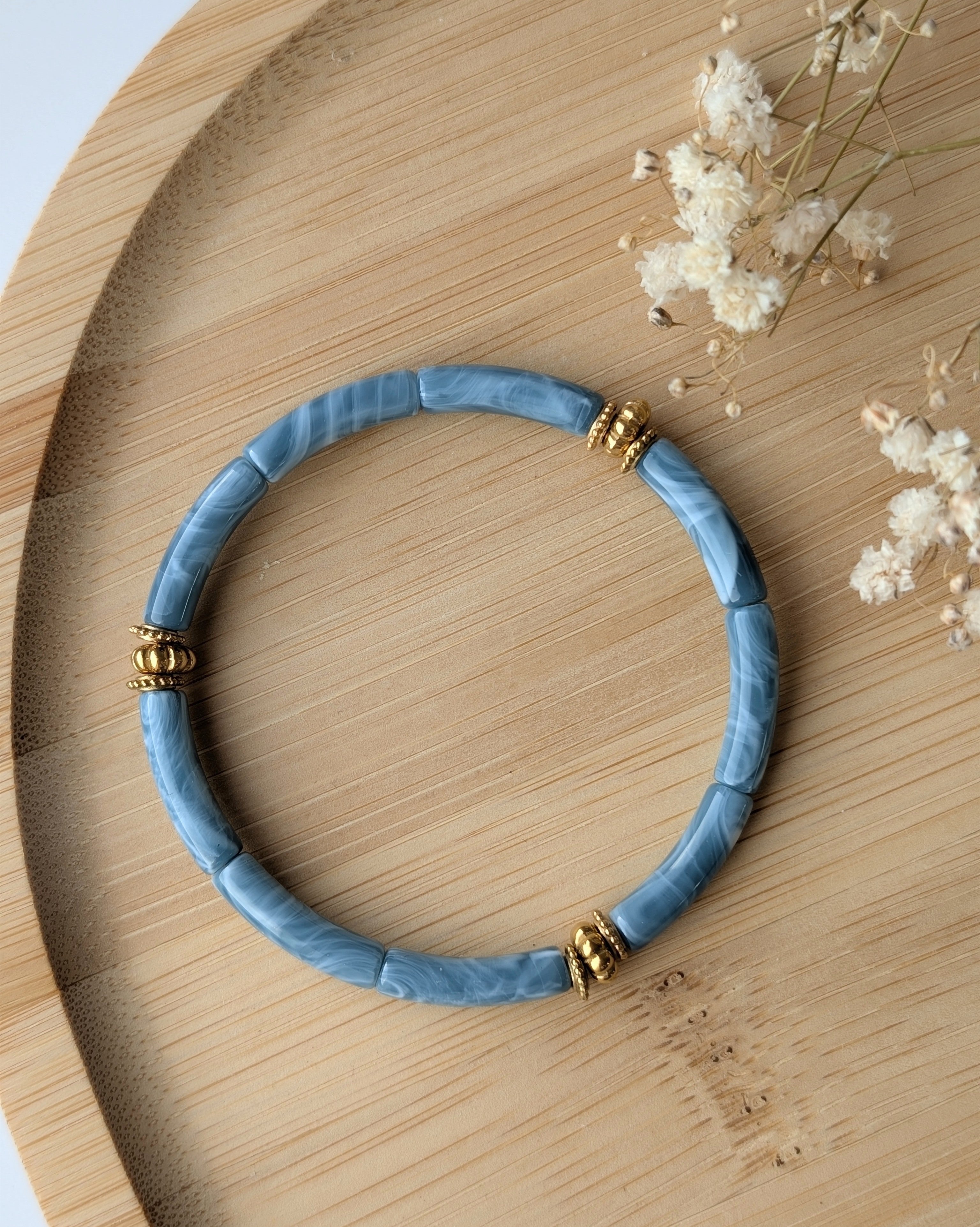 Bracelet perles tube bleu nuage marbré diamètre 5 mm sur support en bois. Bracelet June Détails perles dorées en acier inoxydable doré. Création la Tête dans les Nétoiles