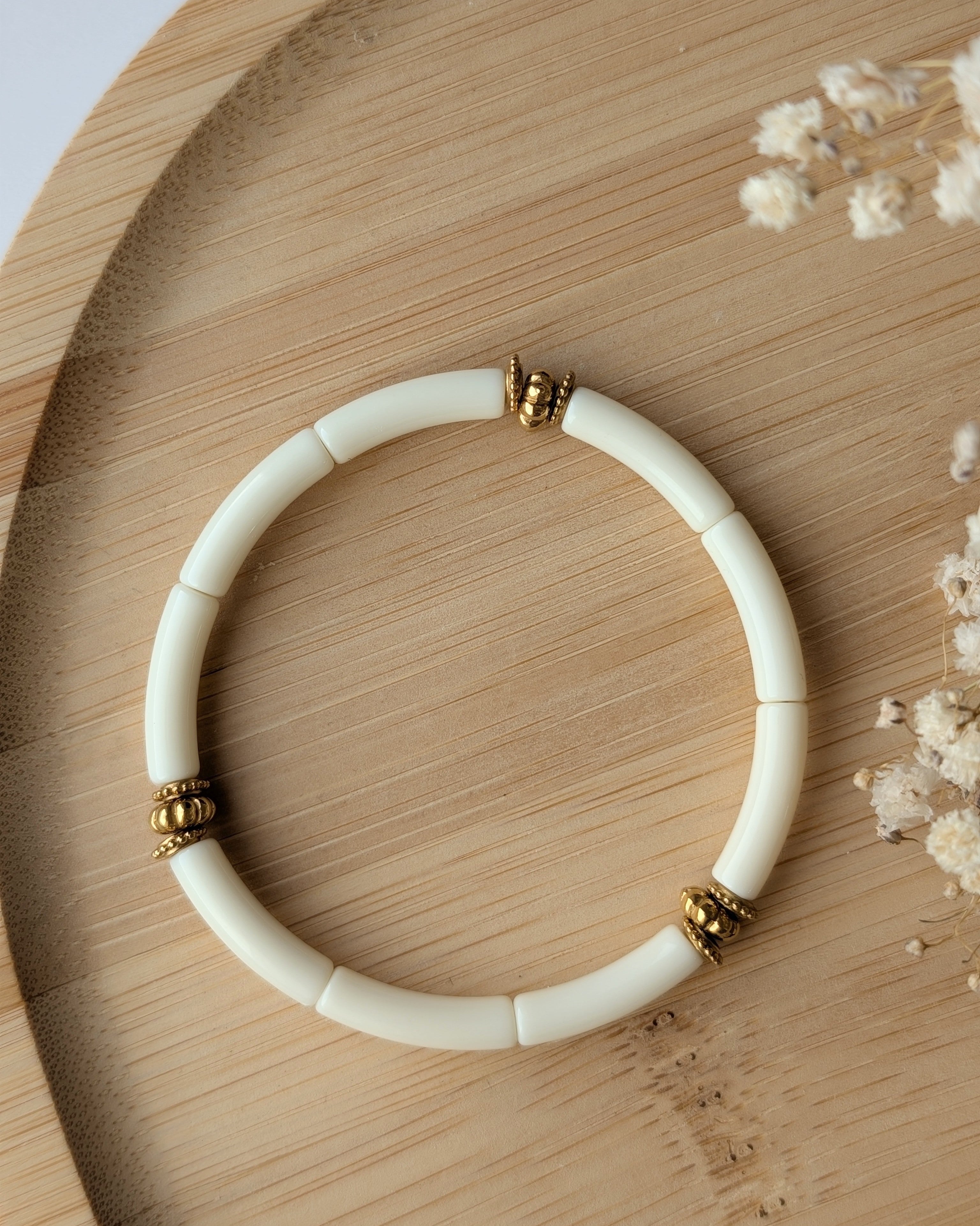 Bracelet perles tube écru diamètre 5 mm sur support en bois. Bracelet June Détails perles dorées en acier inoxydable doré. Création la Tête dans les Nétoiles