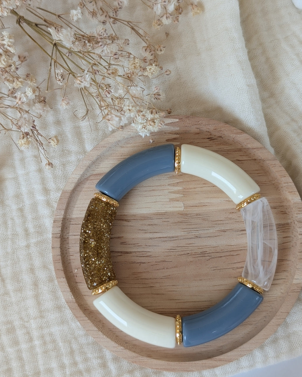 Bracelet perles tube Marie bleu blans transparent et glitter doré avec perles intercalaires dorées haute qualité. Sur support en bois. Création La Tête dans les nétoiles