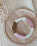 Bracelet perles tube rose tendre taille enfant posé sur support en bois. Création La Tête dans les nétoiles