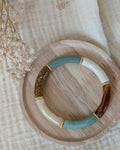 bracelet lison perle tube vert sauge pastel et glitter doré. Avec intercalaire doré. posé sur plateau en bois. Création La Tête dans les Nétoiles