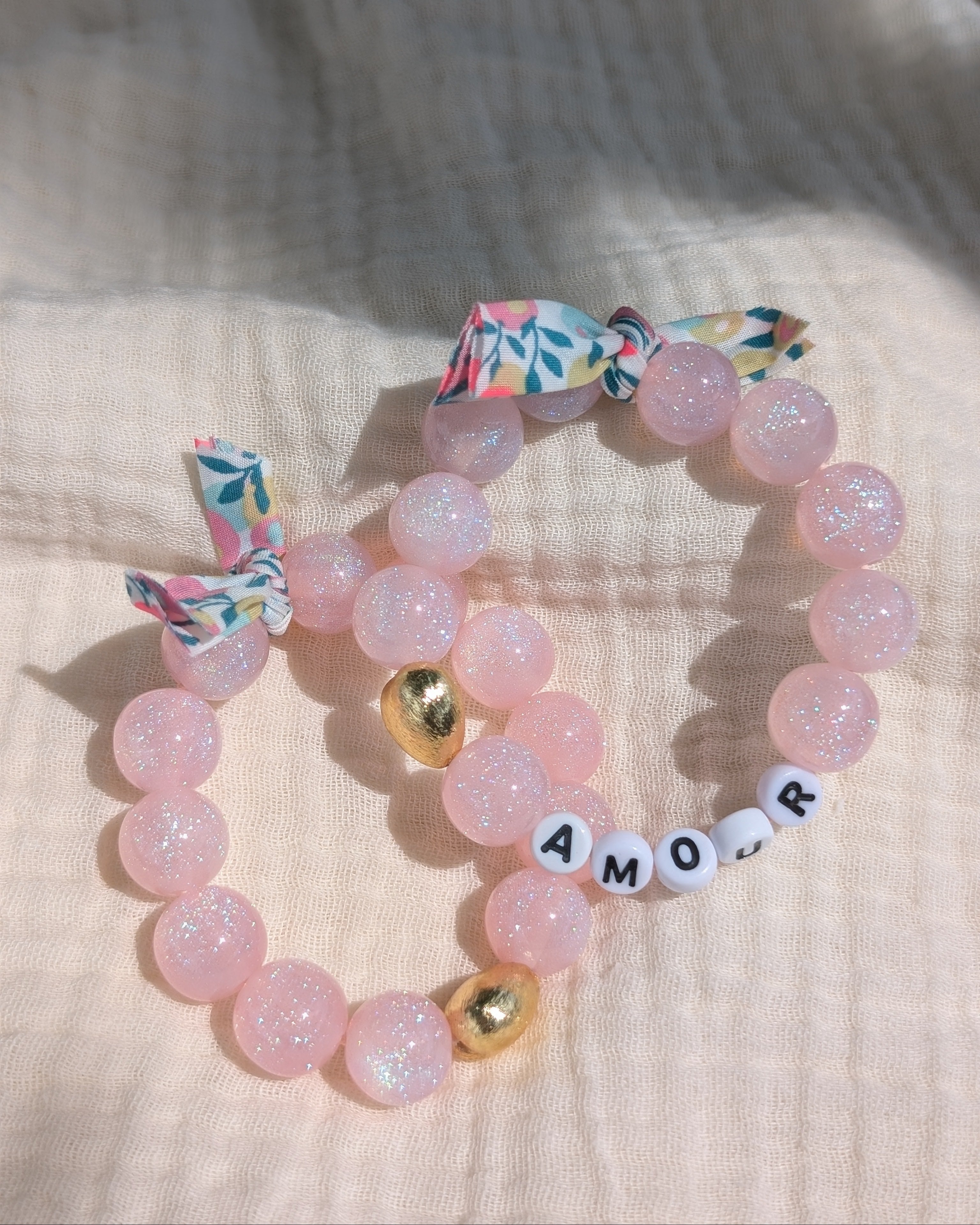 2 bracelets liberty glowy perles à paillettes rose clair et coeur doré. Orné d'un ruban liberty. avec message amour à personnaliser. Créations La Tête dans les Nétoiles 
