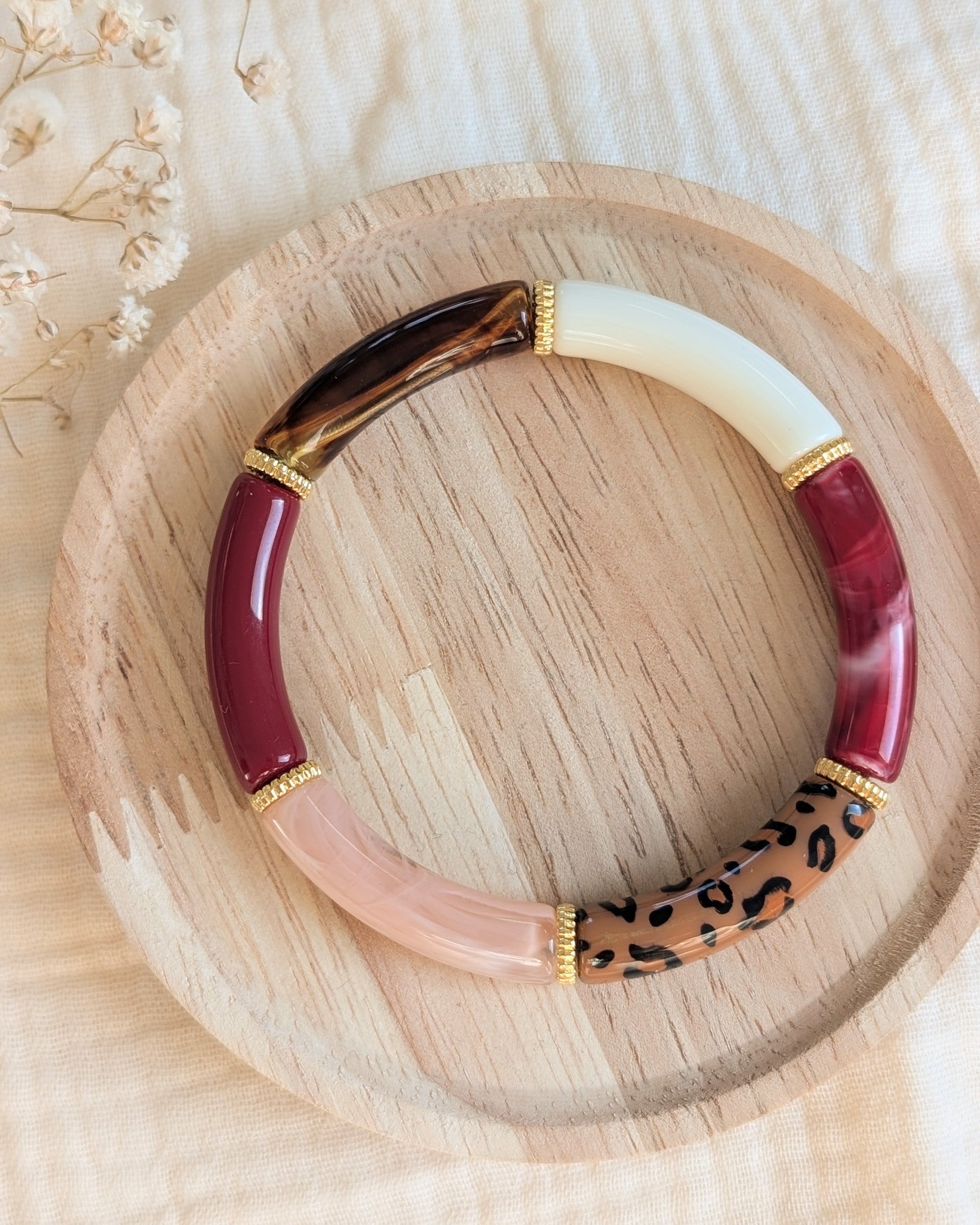 Bracelet perles tube Lison bordeaux léopard sur support en bois. Créations artisanales la Tête dans les Nétoiles 
