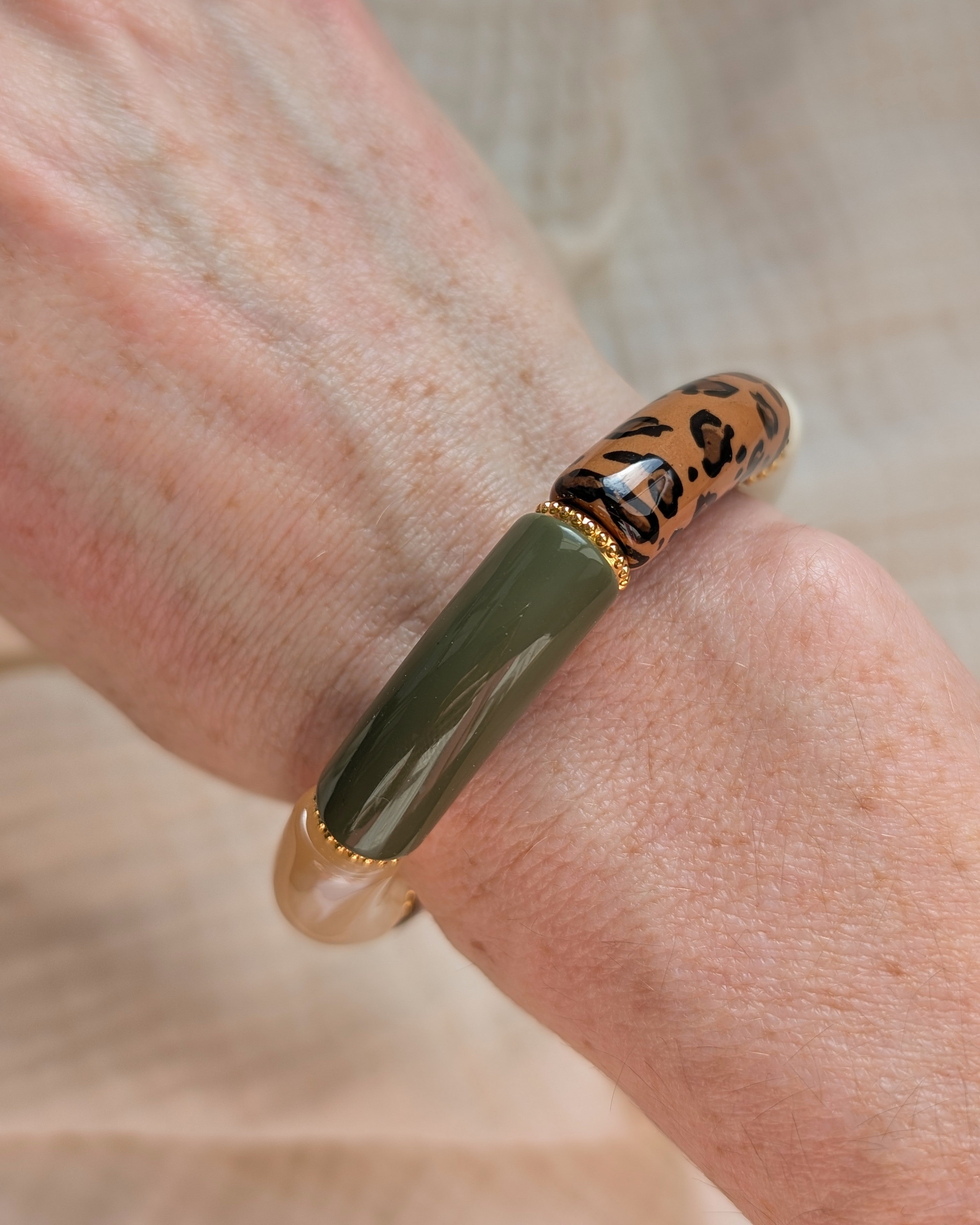 Bracelets perles tube Marie vert kaki militaire et léopard avec perles intercalaires dorées haute qualité. Porté au poignet d'une femme. Création La Tête dans les nétoiles
