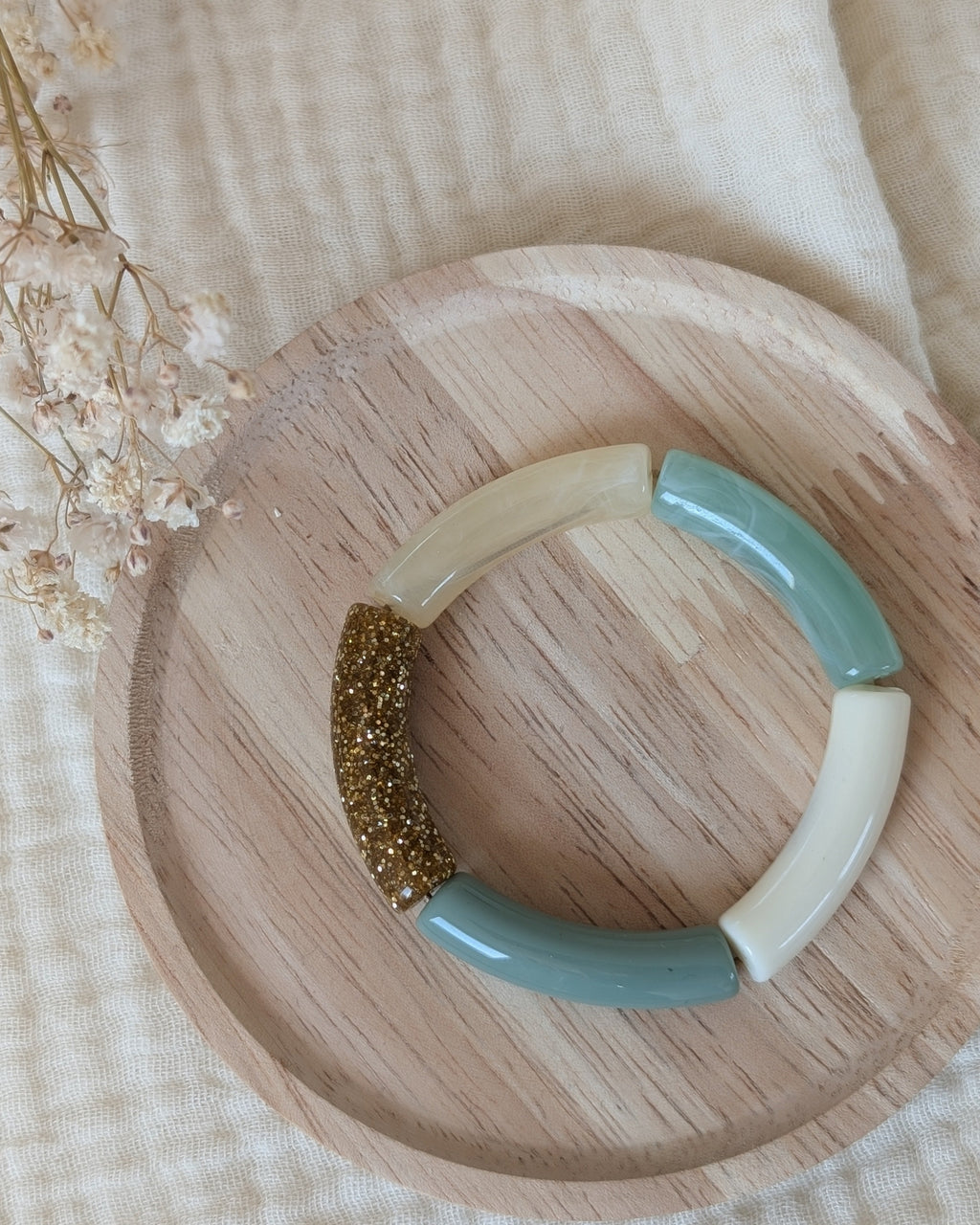 Bracelet perles tube Mini Lisa taille enfant posé sur support en bois. de couleur vert sauge pastel. Création La Tête dans les Nétoiles