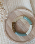 Bracelet perles tube Mini Lisa taille enfant posé sur support en bois. de couleur vert sauge pastel. Création La Tête dans les Nétoiles