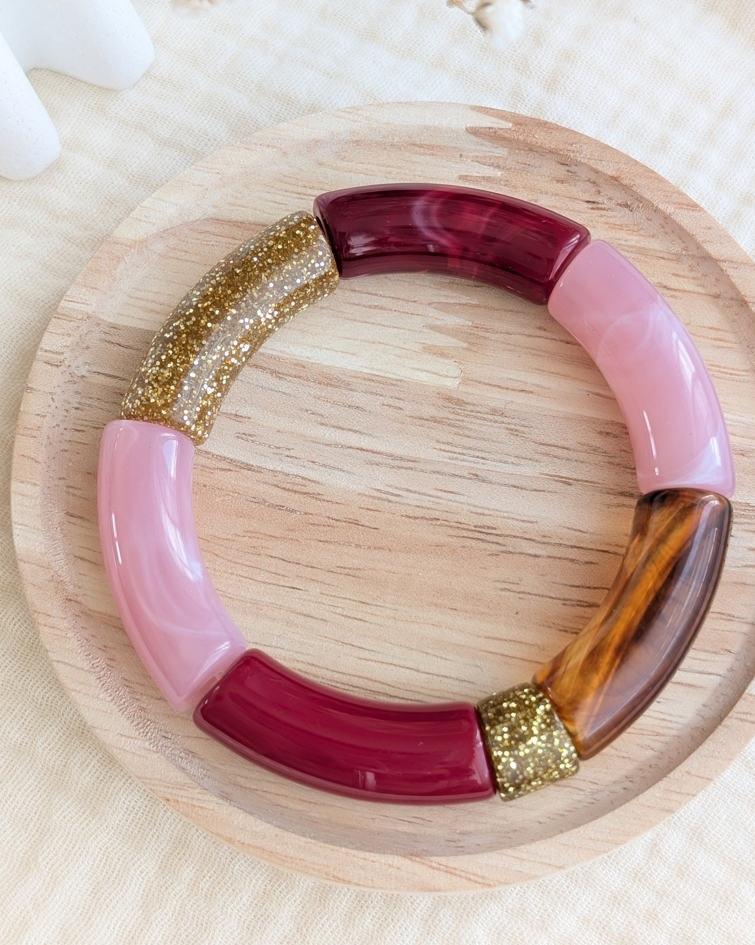 Bracelet perles tube Mona bordeaux rose glitter sur support en bois Créations bijoux la Tête dans les Nétoiles