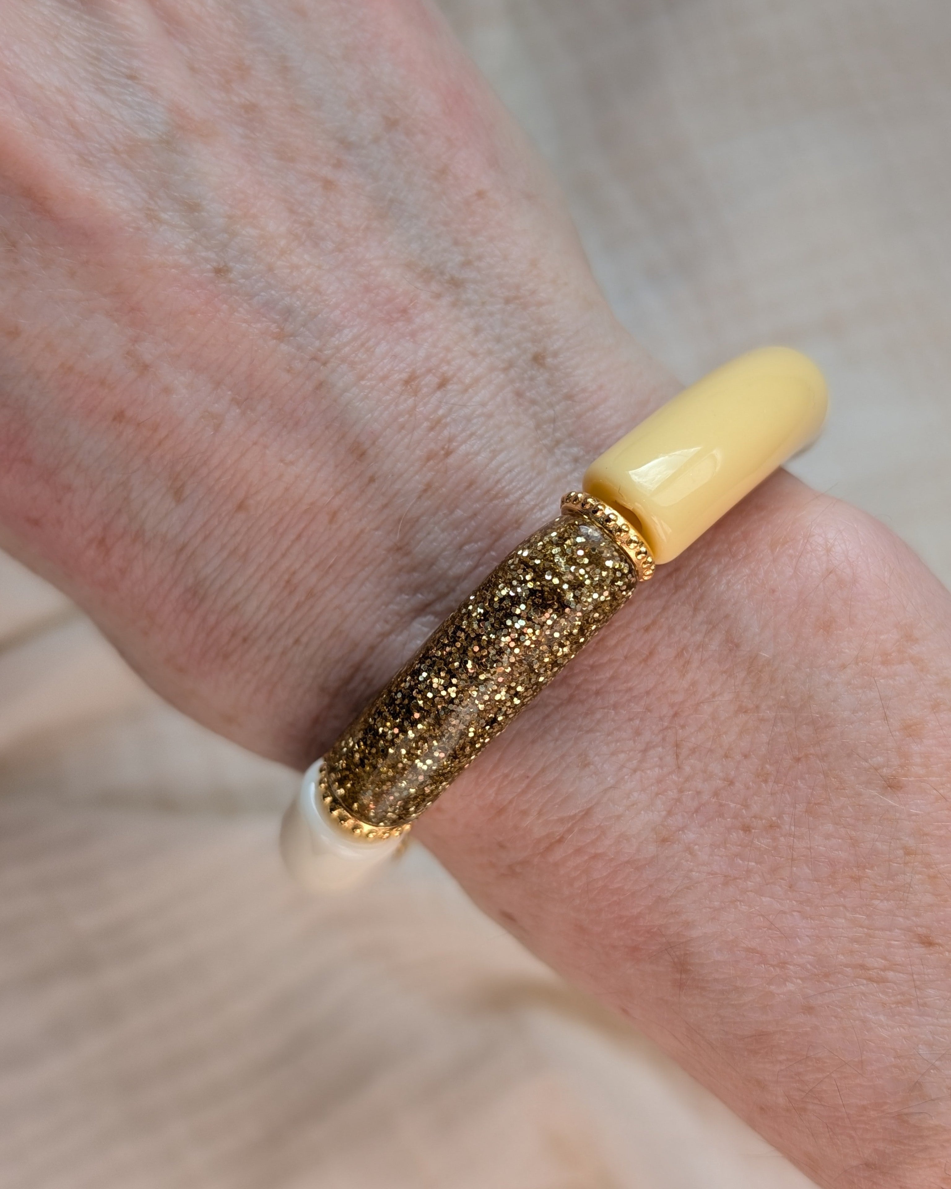 Bracelets perles tube jaune pastel Marie avec perles intercalaires dorées haute qualité. Porté au poignet d'une femme. Création La Tête dans les nétoiles