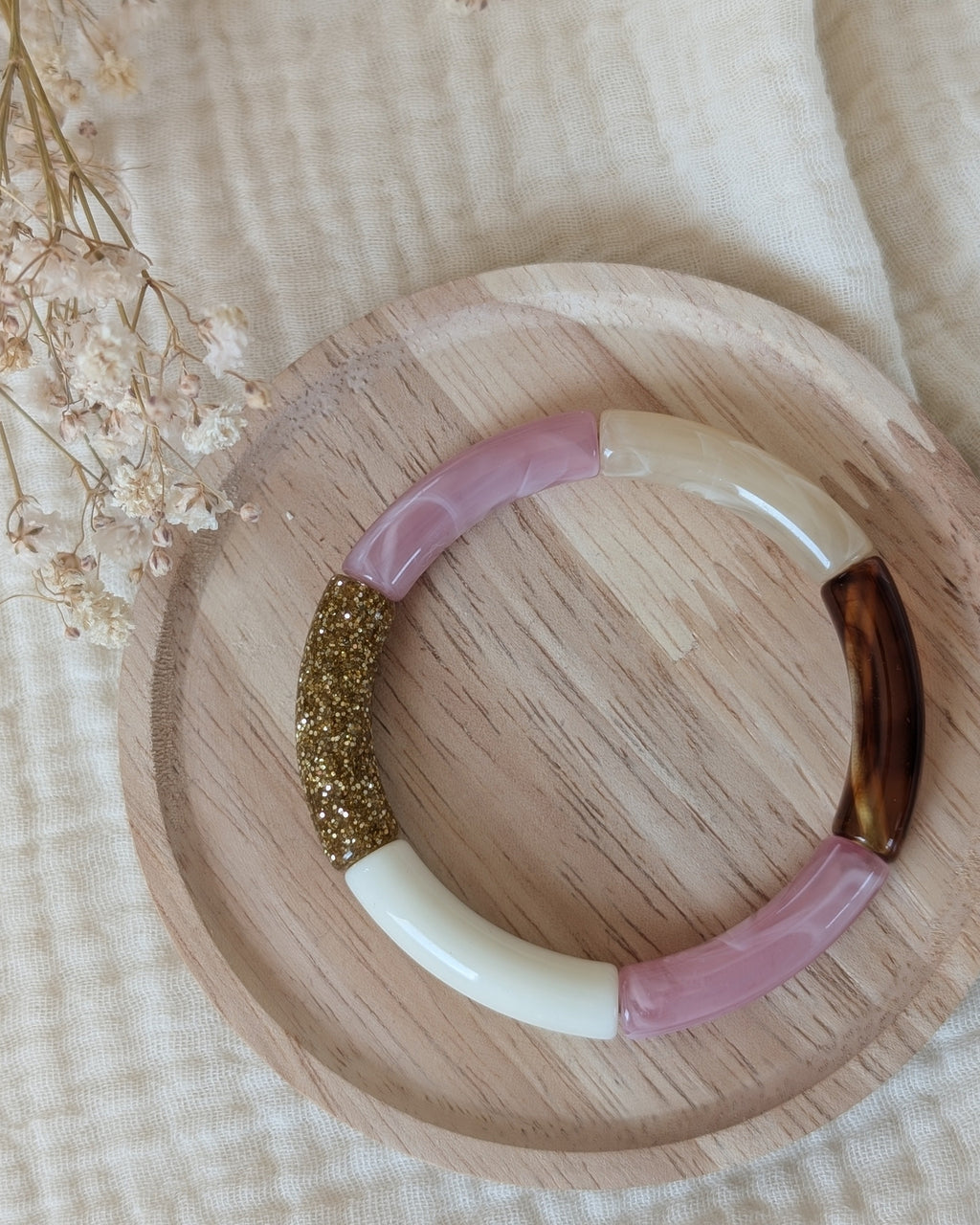 Bracelet perles tube Lisa rose tendre posé sur support en bois. Création La Tête dans les Nétoiles