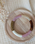 Bracelet perles tube Lisa rose tendre posé sur support en bois. Création La Tête dans les Nétoiles