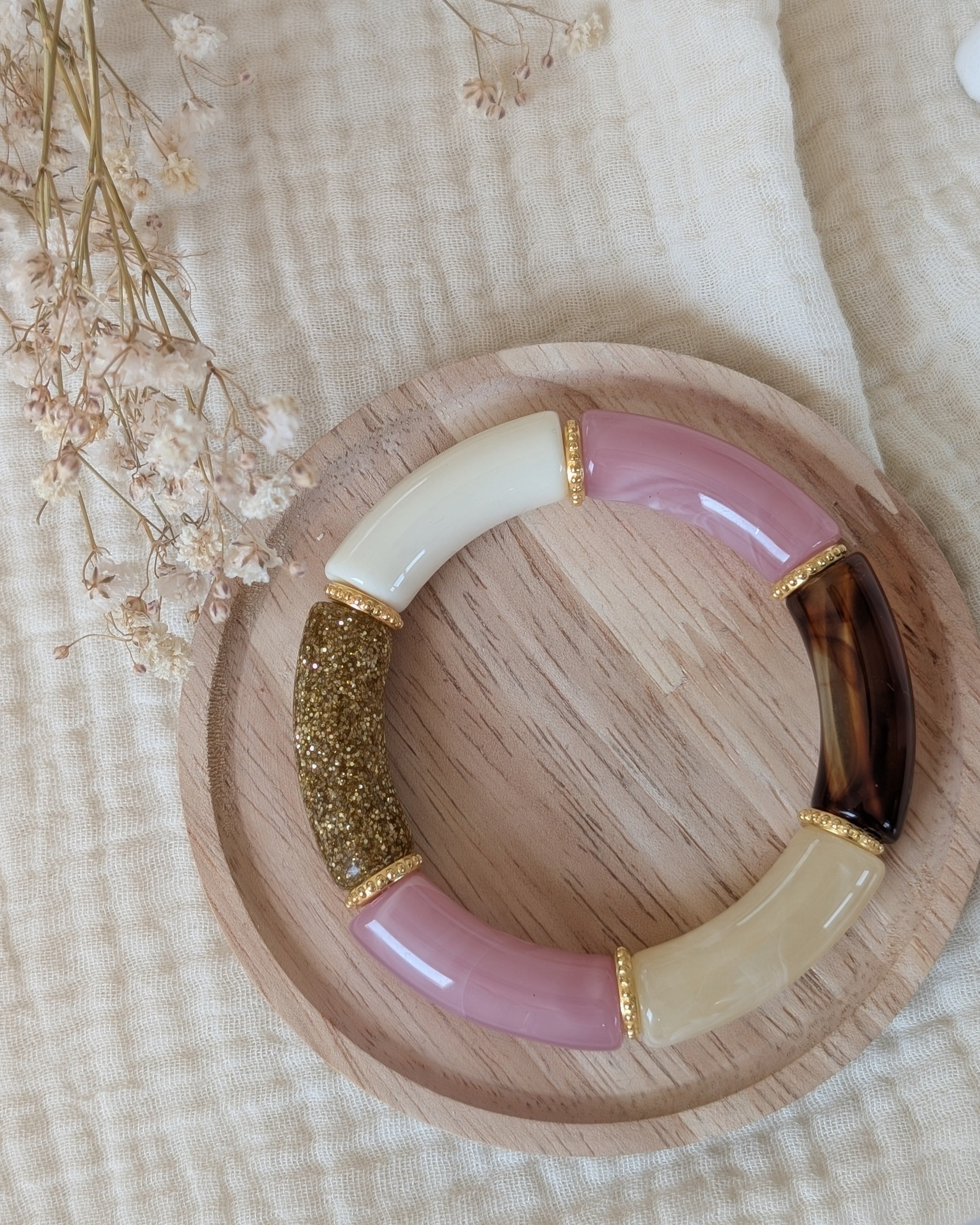 Bracelet perles tube marie en rose et glitter doré. Avec perles intercalaires dorées haute qualité. Sur support en bois. Création La Tête dans les nétoiles