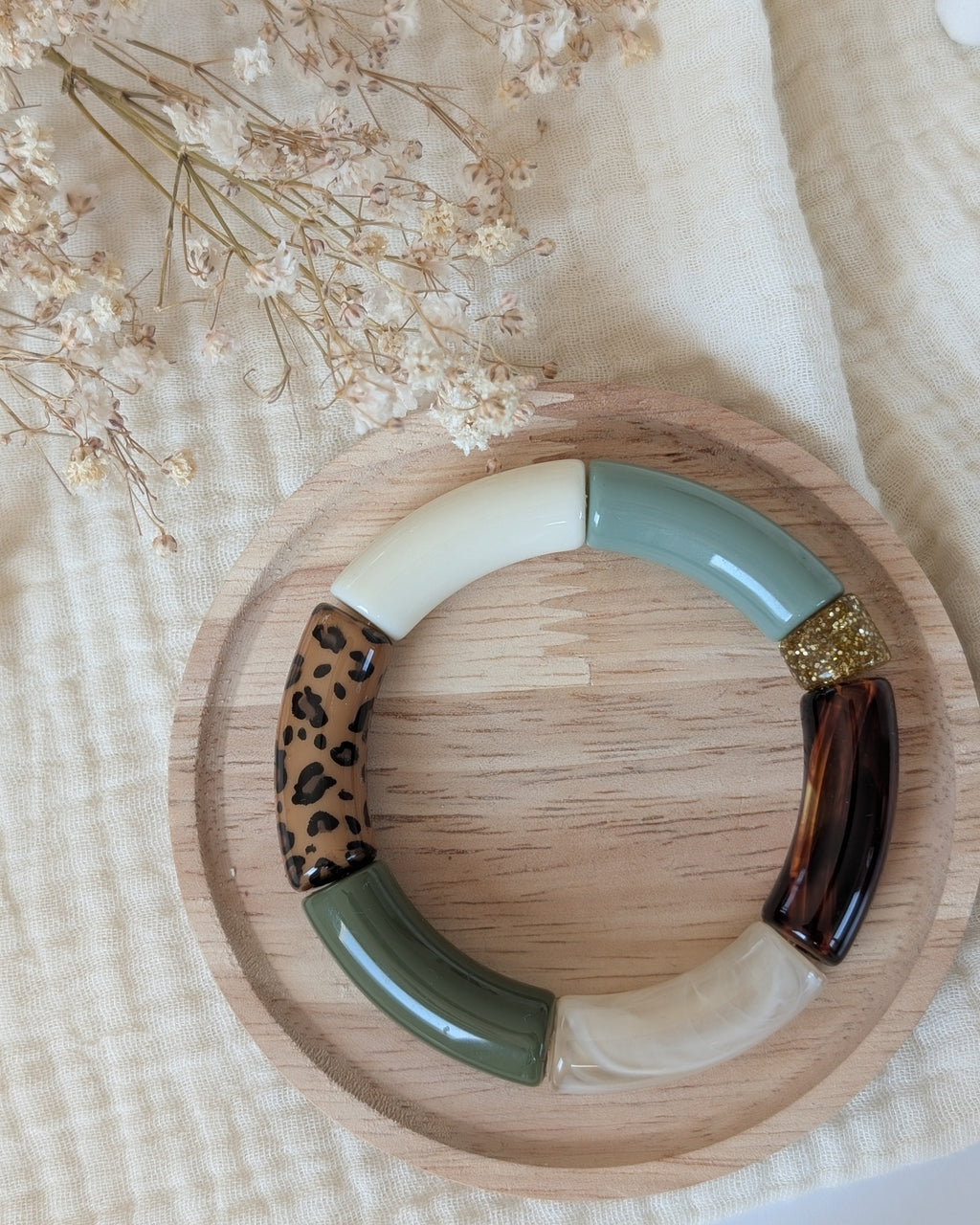 Bracelet perles tube mona vert et léopard sur support en bois. Création La Tête dans les Nétoiles