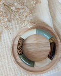 Bracelet perles tube mona vert et léopard sur support en bois. Création La Tête dans les Nétoiles