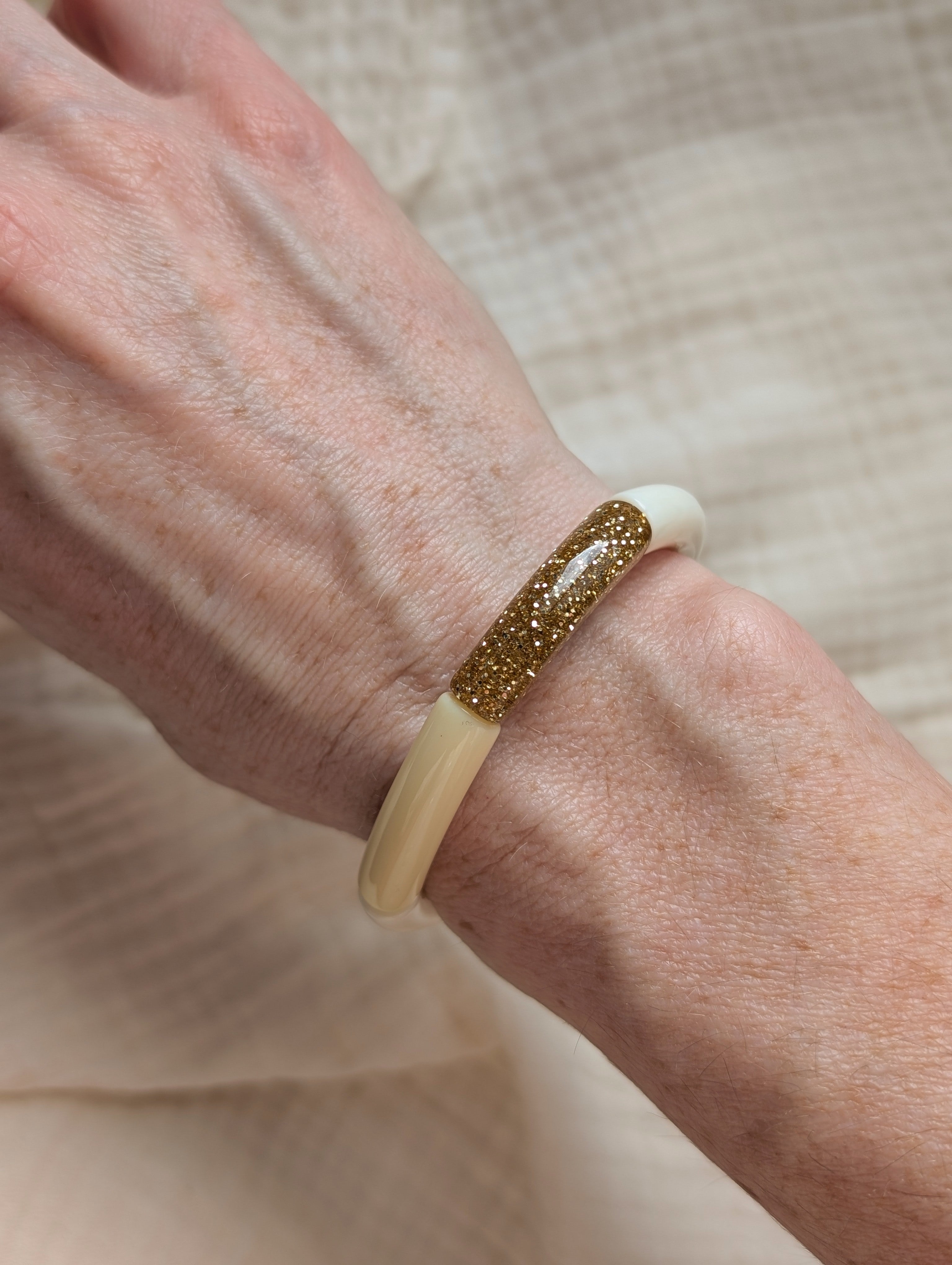Bracelet perles tubes Lisa jaune pastel porté au poignet. Et perle glitter  paillettes doré. Création La Tête dans les Nétoiles