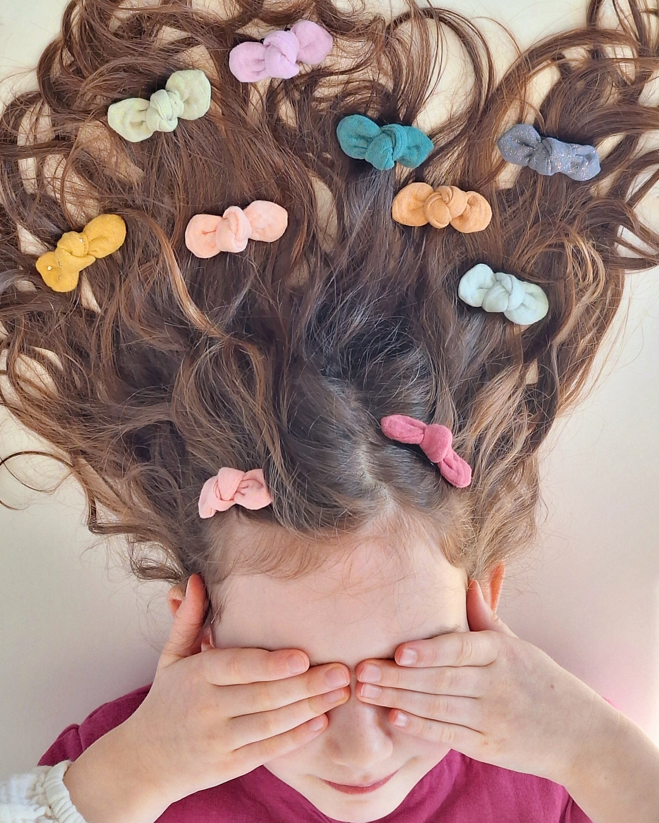 Chevelure petite fille avec barette neud Romie dans les cheveux. créations artisanales La Tête dans les Nétoiles